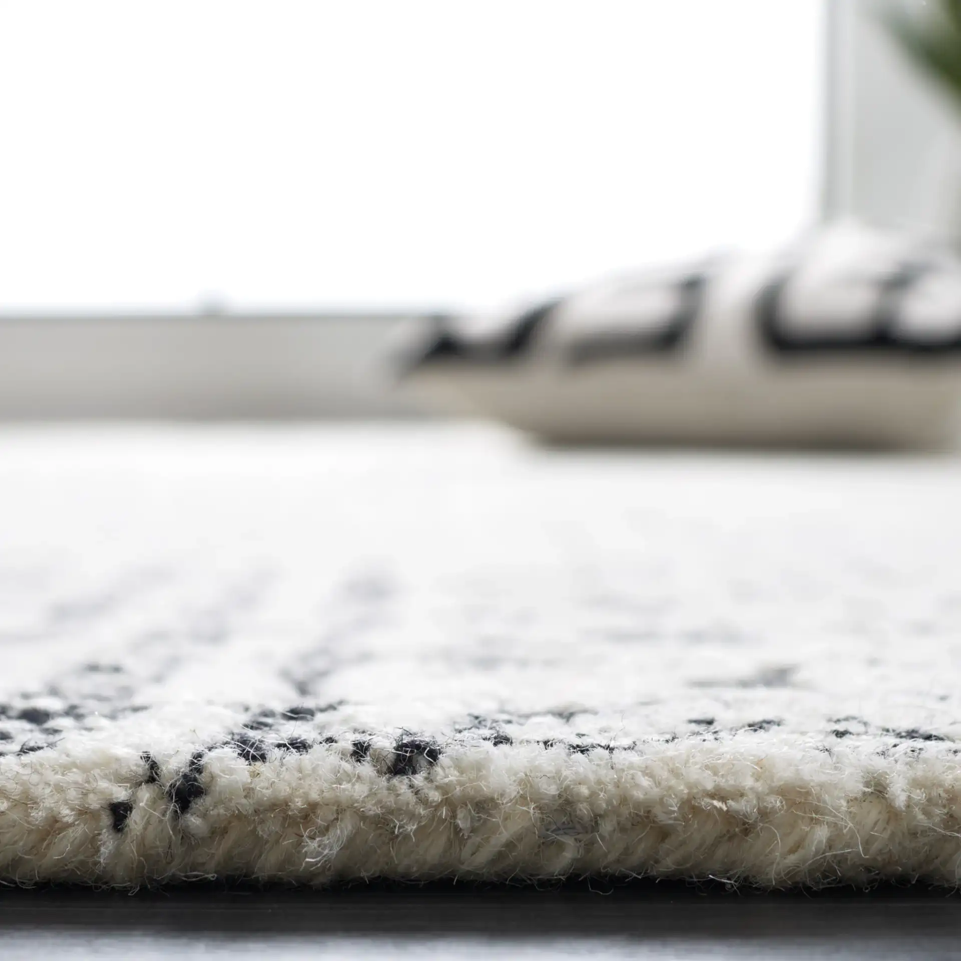 Abstract Boho Patchwork Hand-Tufted Wool Rug in Black / Ivory in a styled room