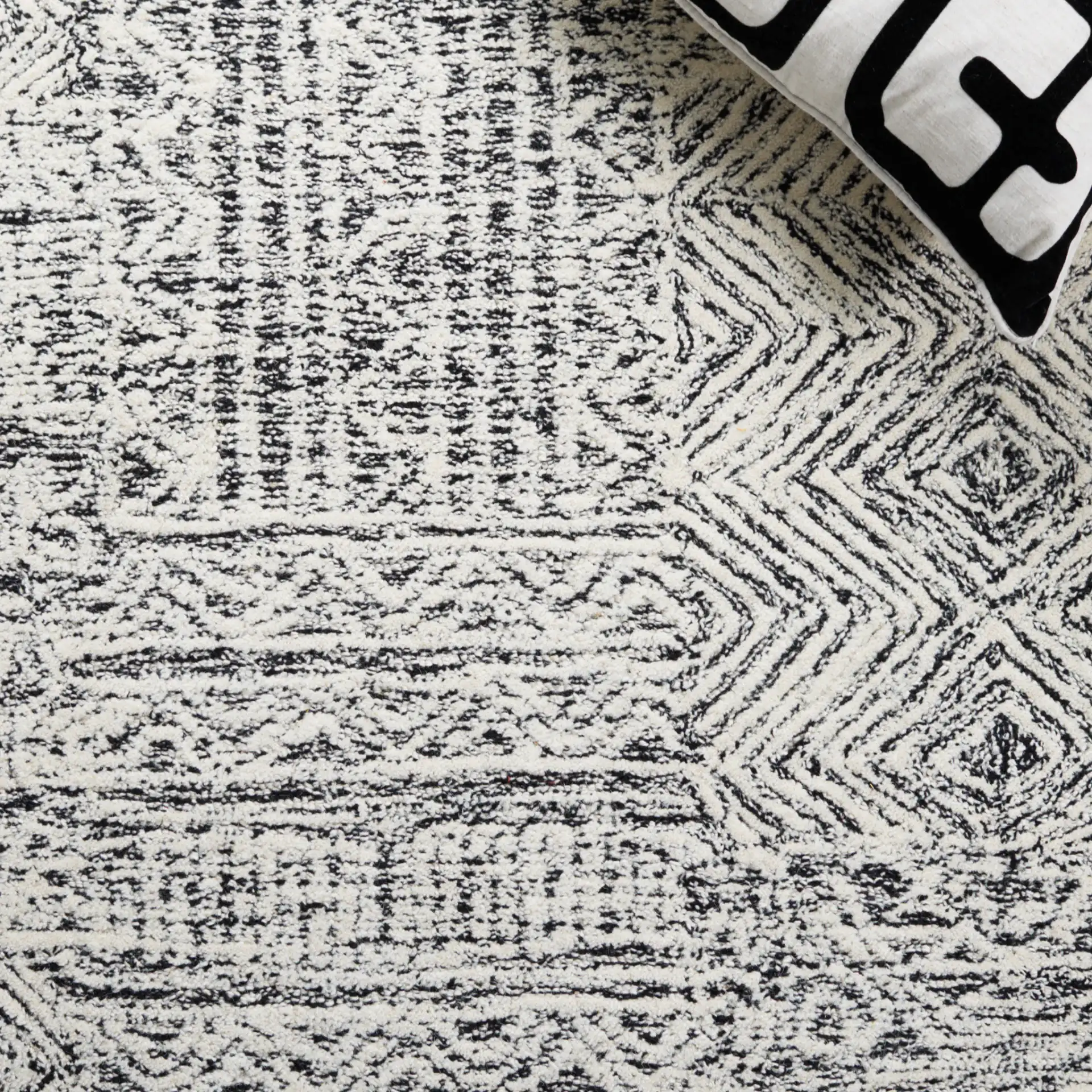 Abstract Boho Patchwork Hand-Tufted Wool Rug in Black / Ivory in a styled room