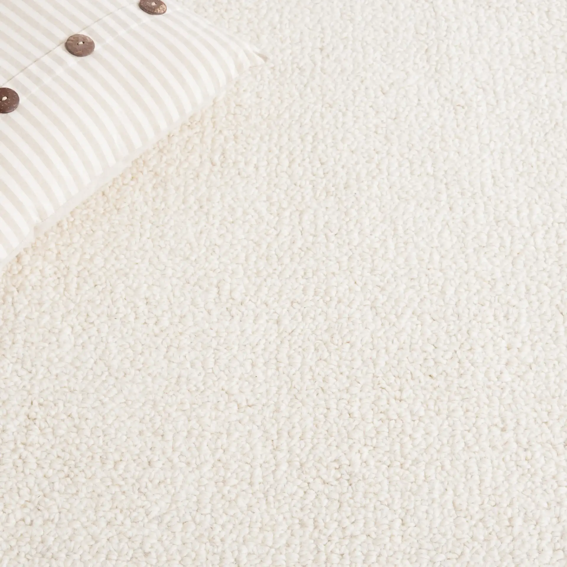 Abstract Modern Textured Solid Hand-Tufted Wool Rug in Ivory in a styled room