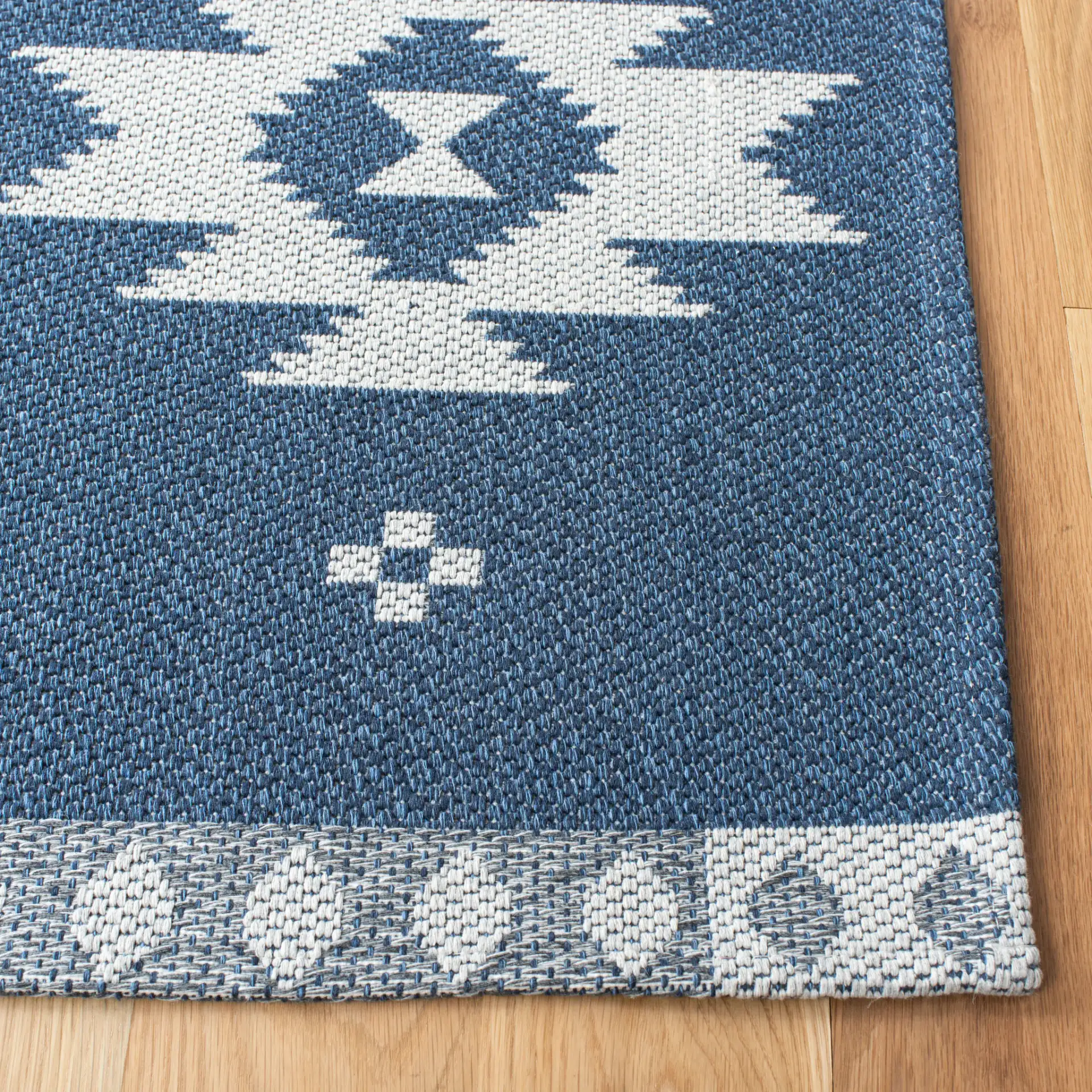 Augustine Banded Diamond Cotton Rug in Navy / Cream in a styled room