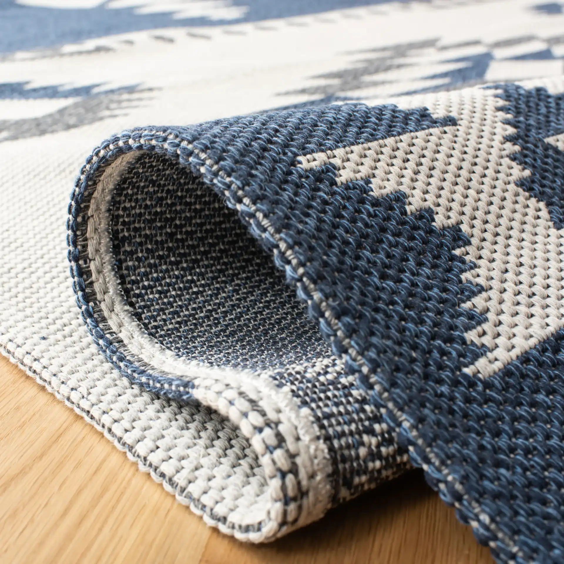 Augustine Banded Diamond Cotton Rug in Navy / Cream in a styled room