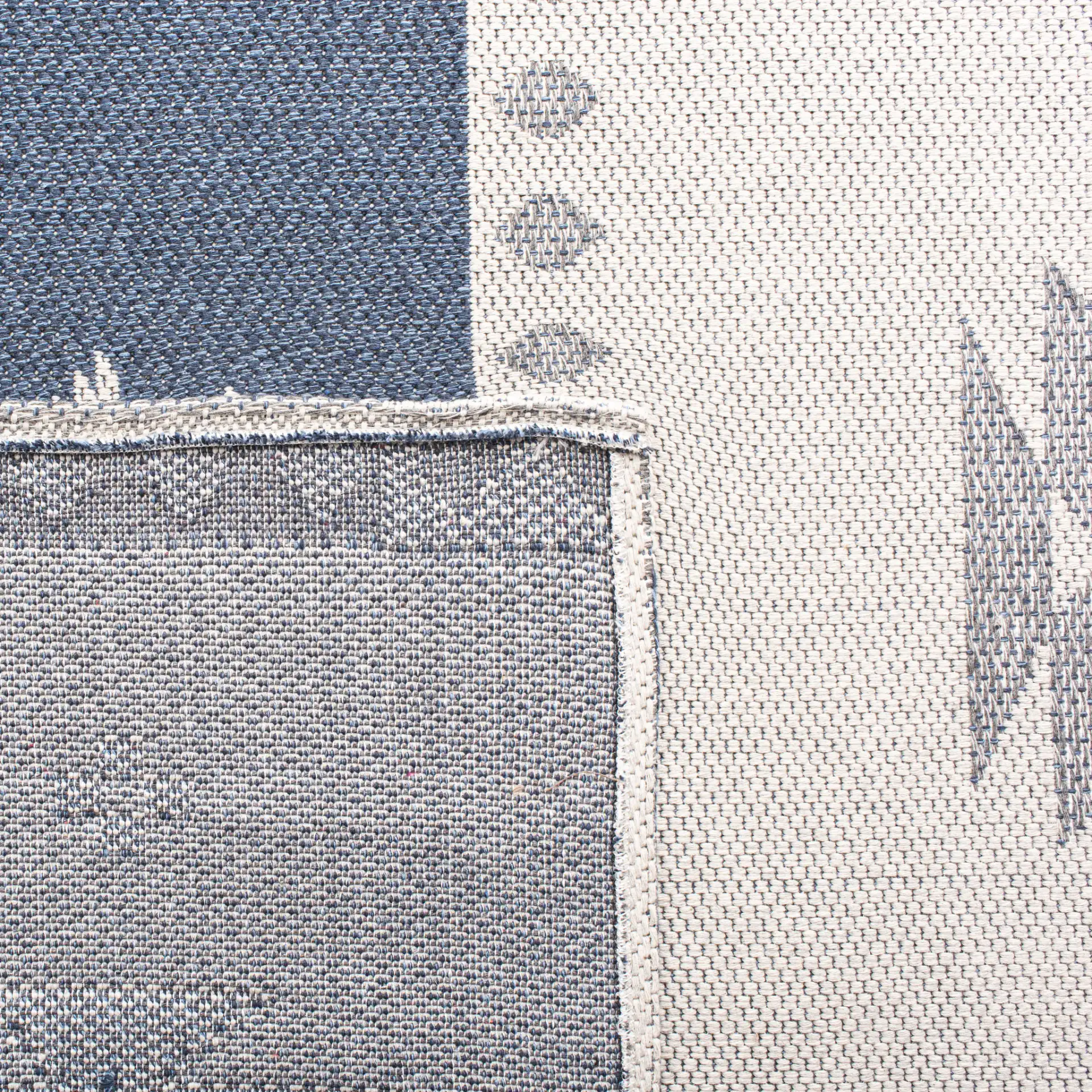Augustine Banded Diamond Cotton Rug in Navy / Cream in a styled room