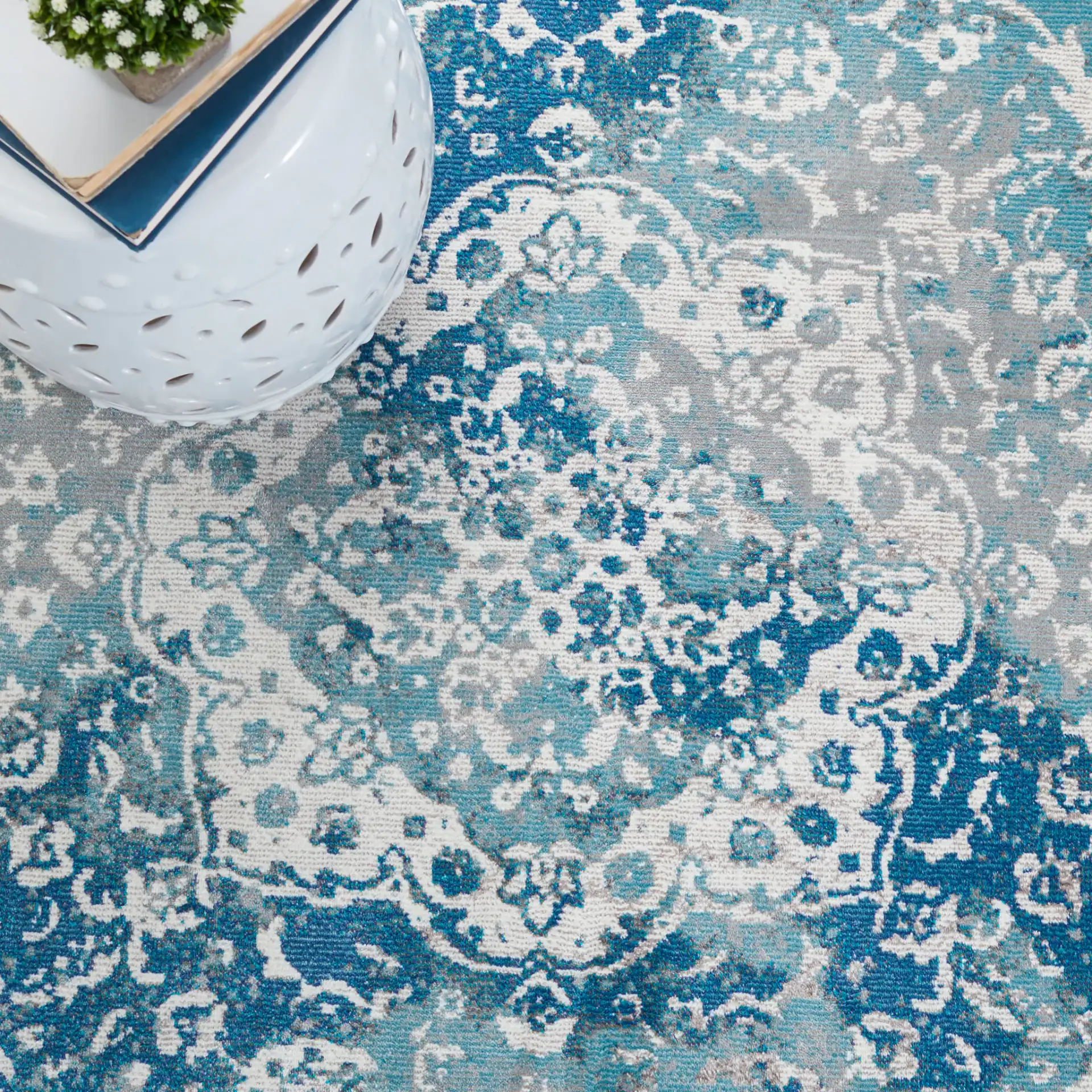 Aria Distressed Rosette Medallion Rug in Light Blue / Ivory in a styled room