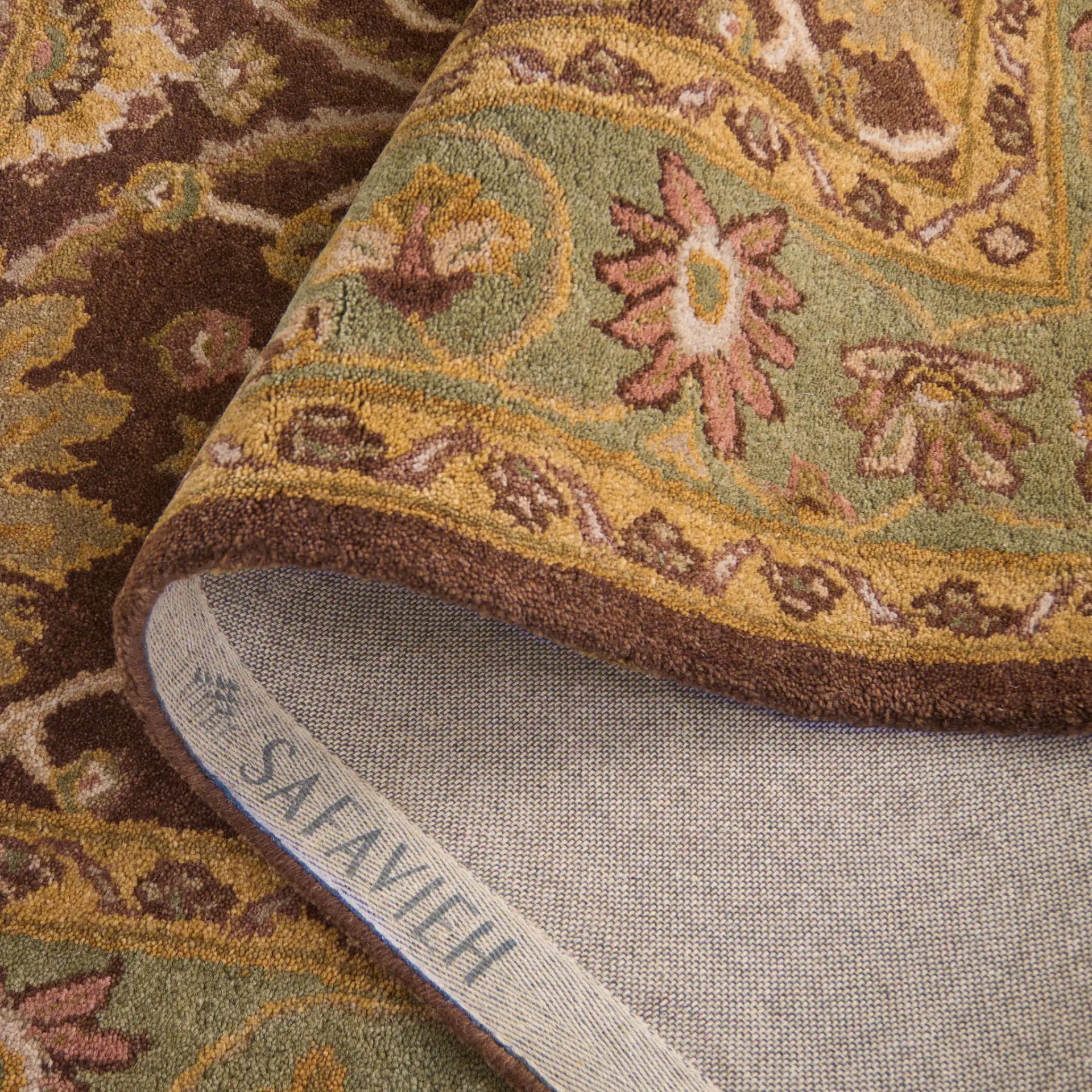 Antiquity Palmette Bordered Hand-Tufted Wool Rug in Chocolate / Blue in a styled room