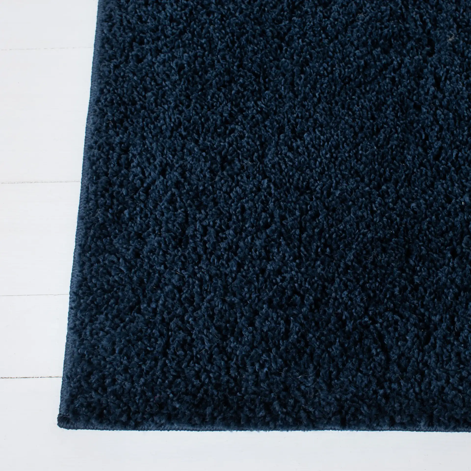 August Solid Shag Rug in Navy in a styled room