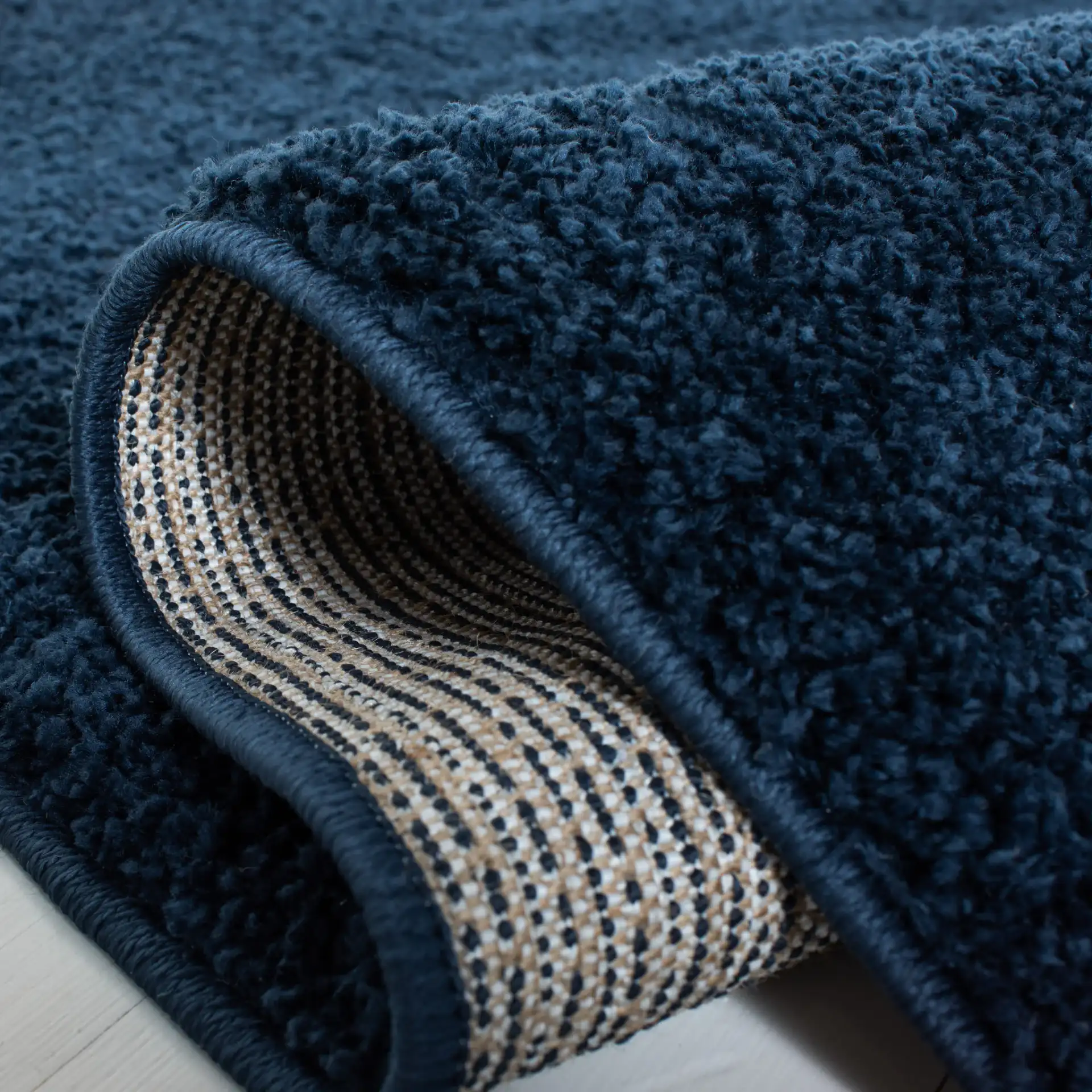 August Solid Shag Rug in Navy in a styled room