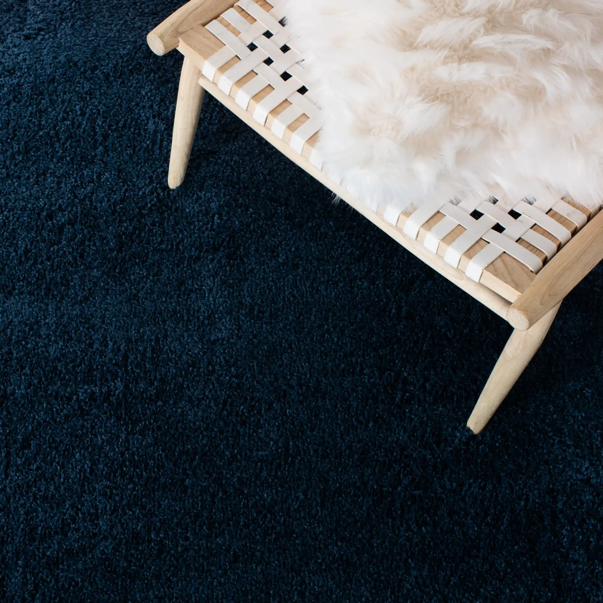 August Solid Shag Rug in Navy in a styled room