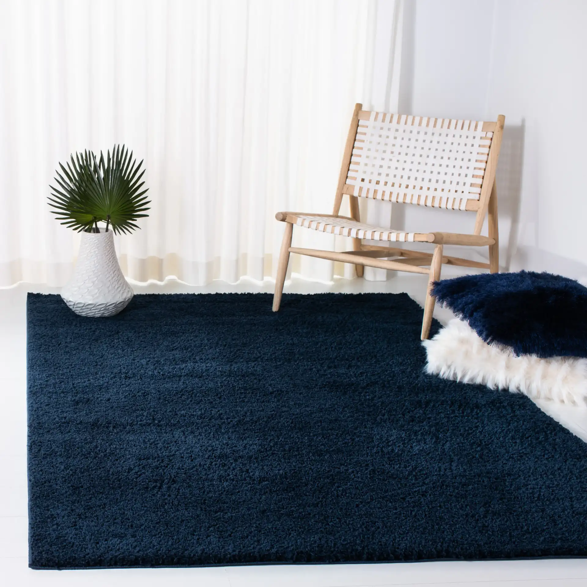 August Solid Shag Rug in Navy in a styled room
