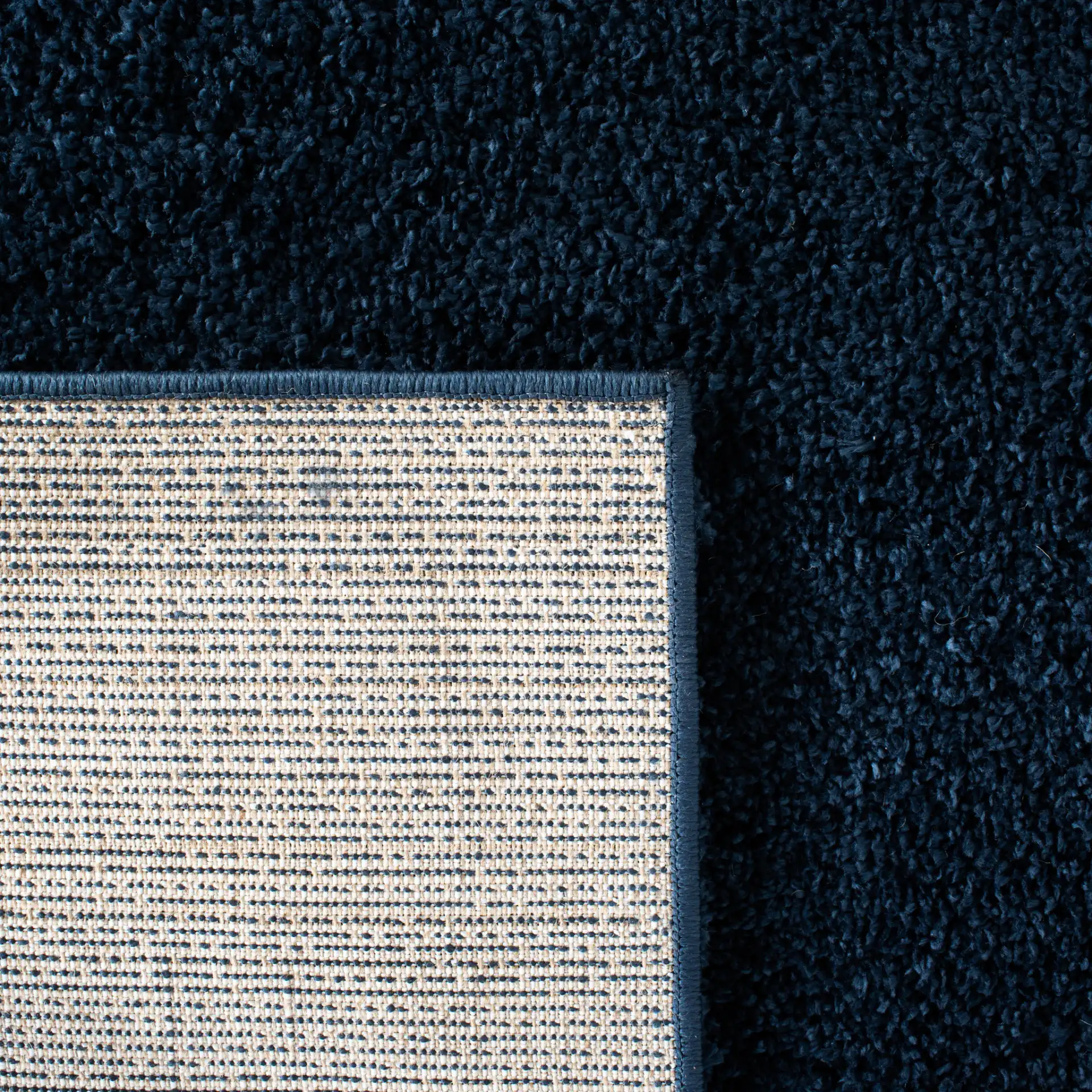 August Solid Shag Rug in Navy in a styled room