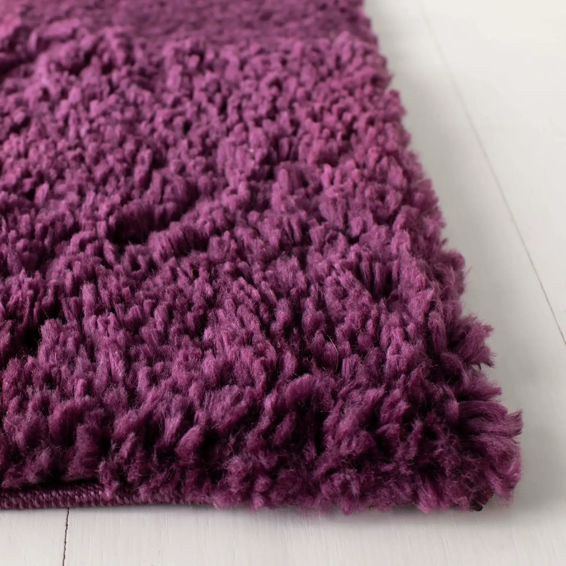 August Solid Shag Rug in Purple in a styled room
