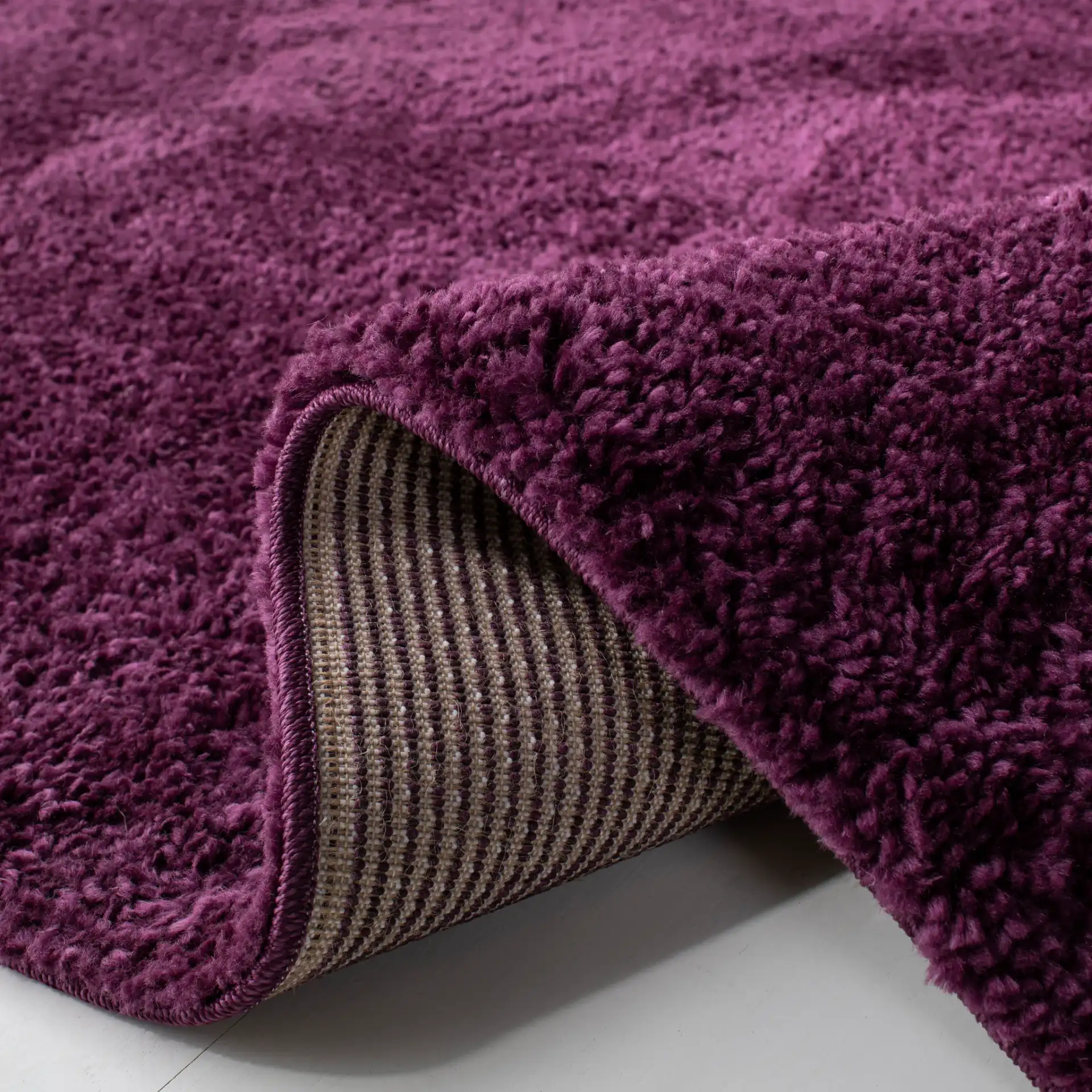 August Solid Shag Rug in Purple in a styled room