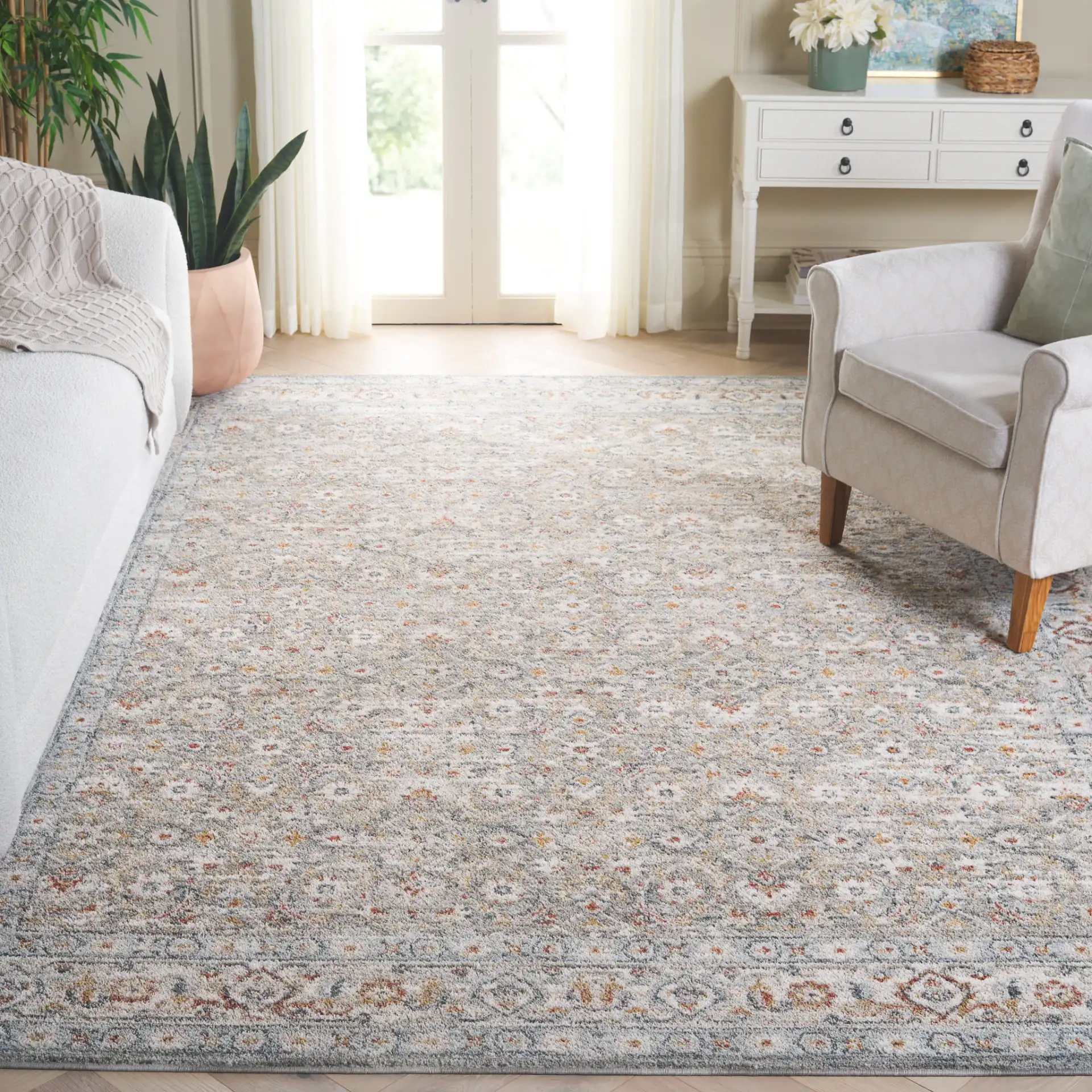 Avalon Floral Bordered Rug in Gray / Light Blue in a styled room