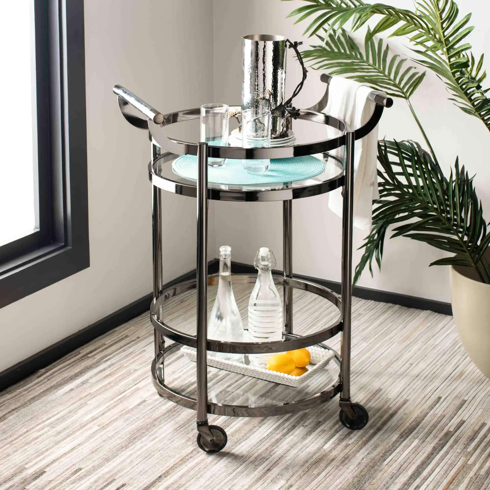 Siena Two-Tier Round Bar Cart in Black Nickel / Clear in a styled room