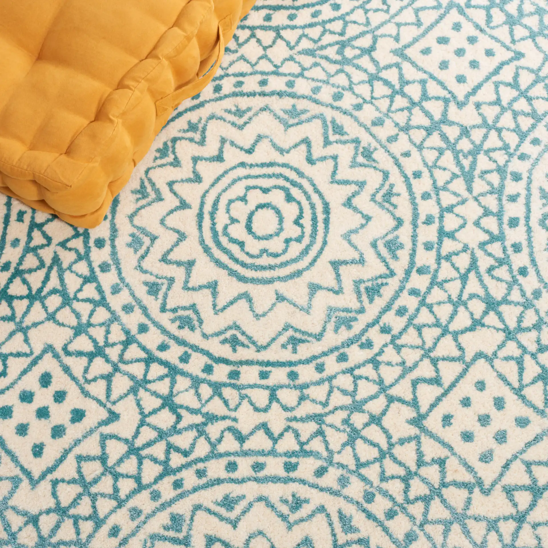 Bella Circular Medallion Hand-Tufted Rug in Ivory / Blue in a styled room