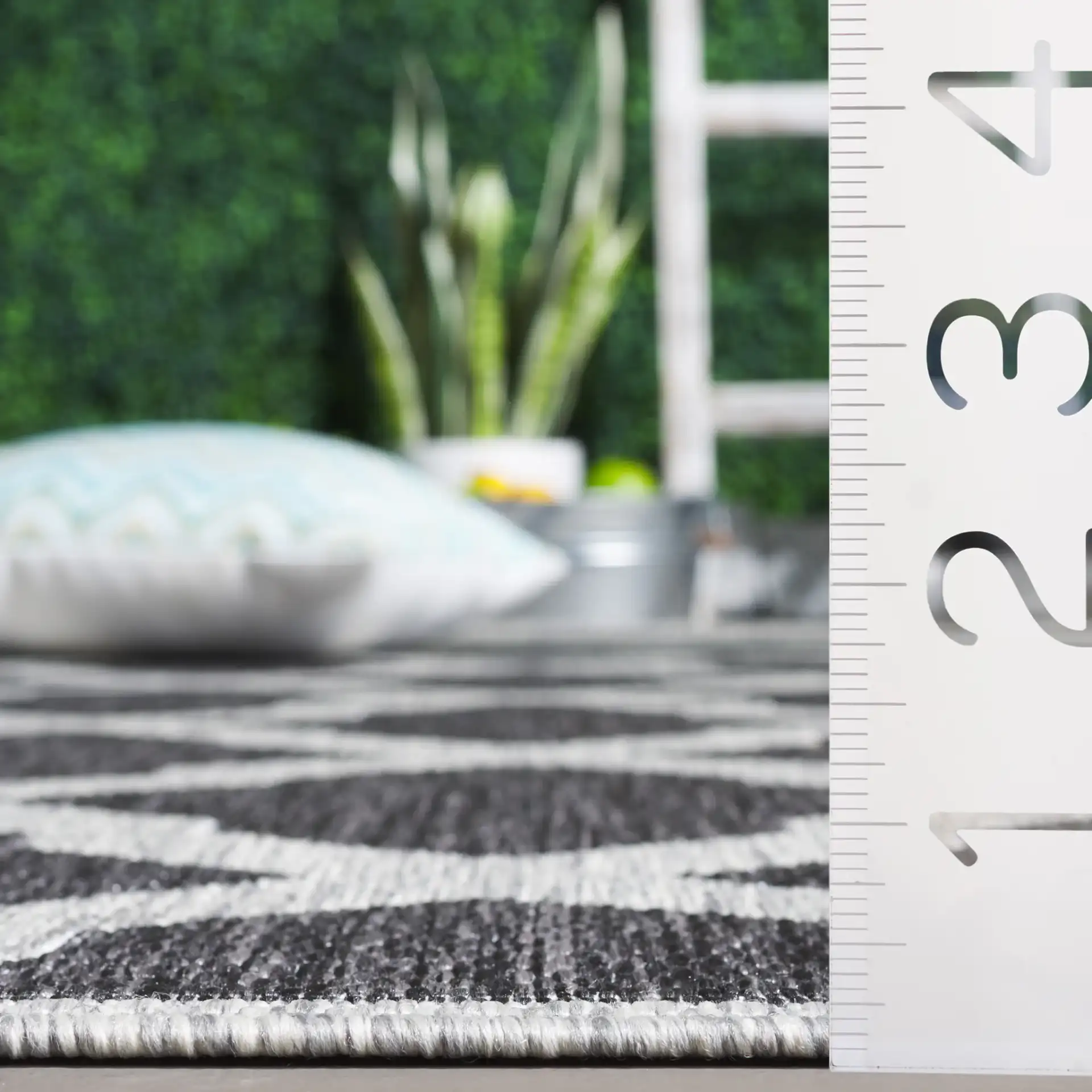 Beach House Moroccan Lattice Outdoor Rug in Charcoal / Gray in a styled room