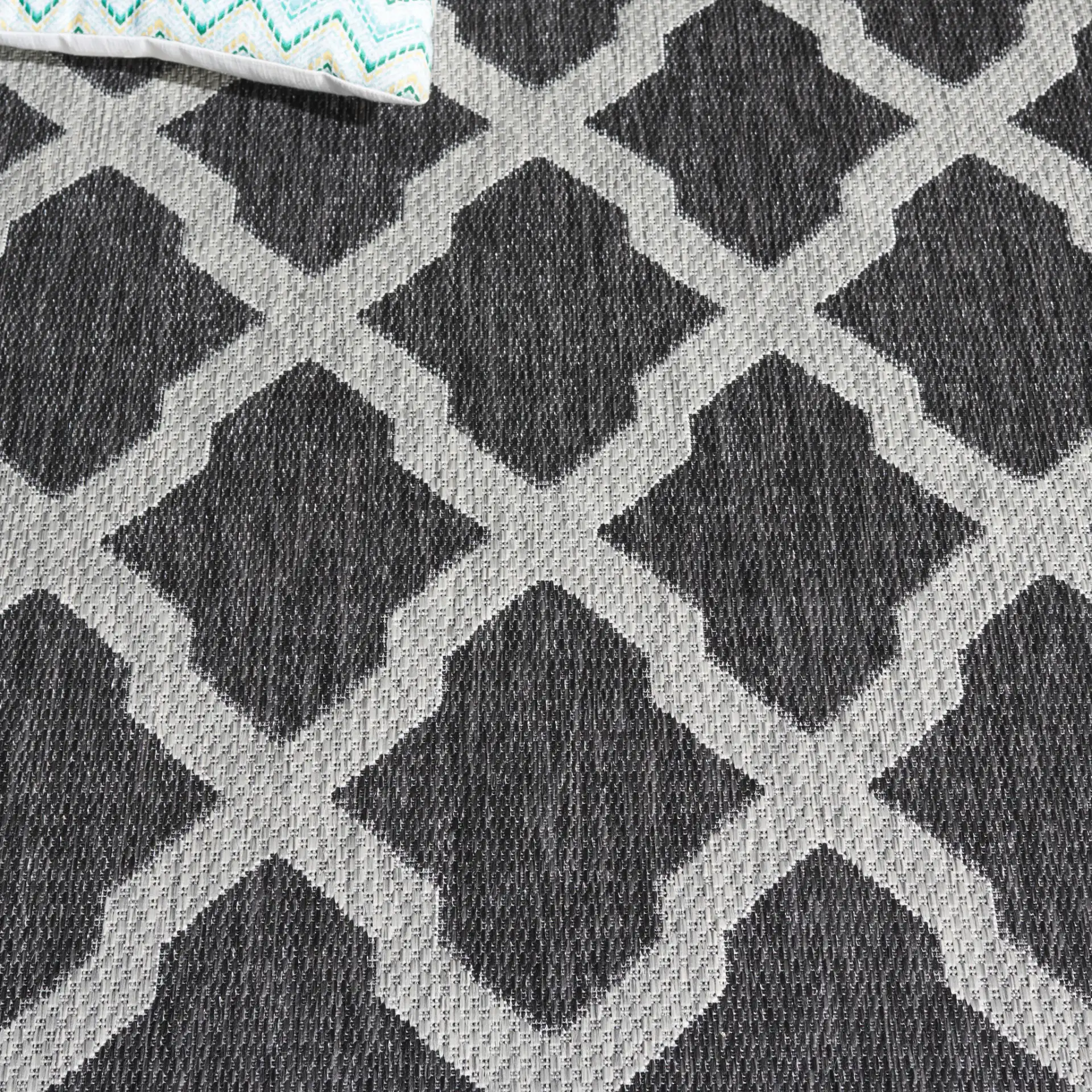 Beach House Moroccan Lattice Outdoor Rug in Charcoal / Gray in a styled room