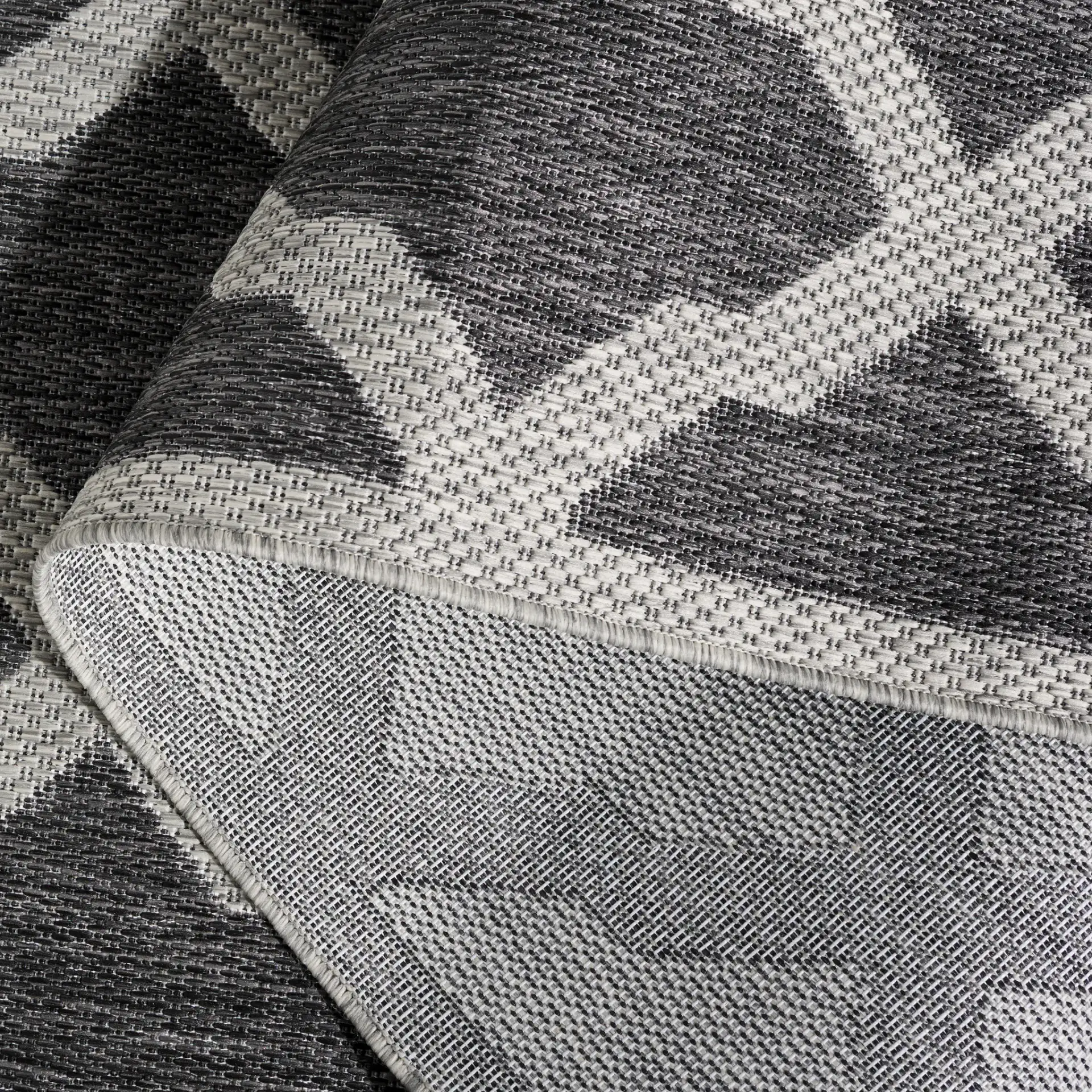 Beach House Moroccan Lattice Outdoor Rug in Charcoal / Gray in a styled room