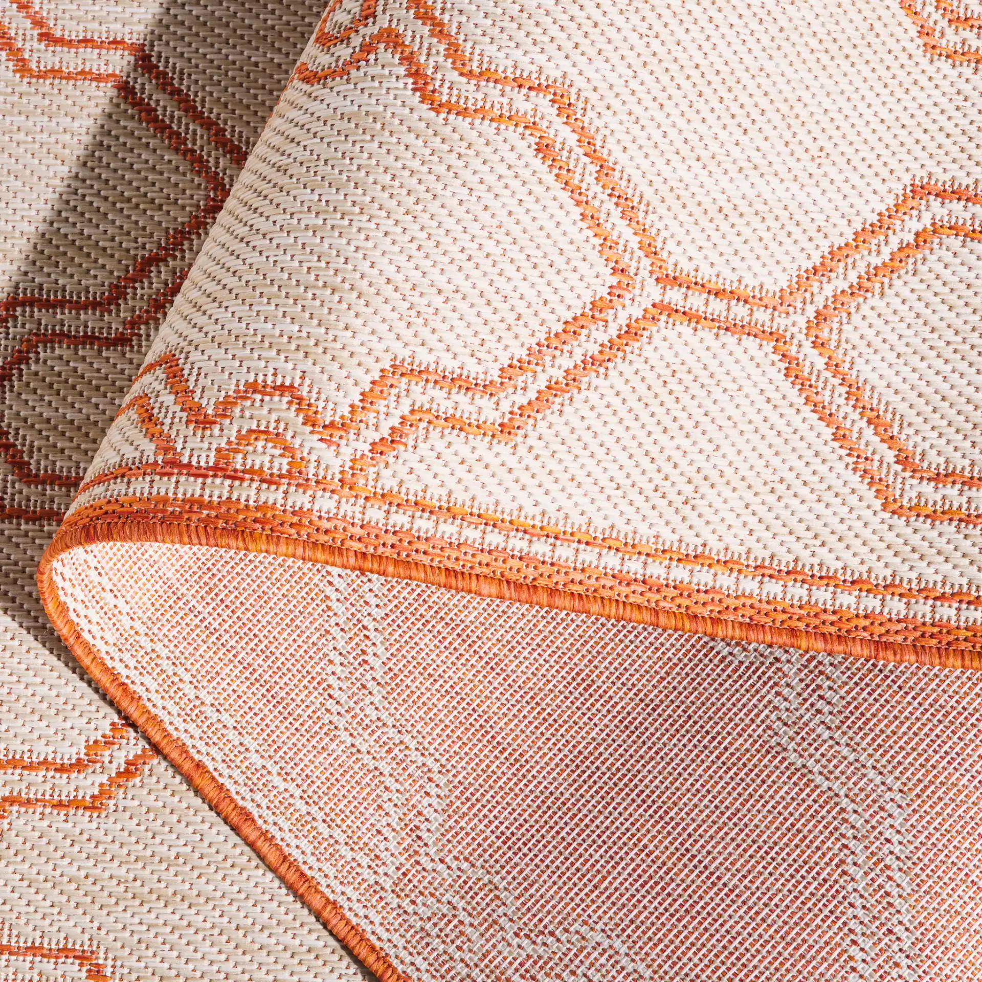 Beach House Geometric Trellis Outdoor Rug in Beige / Orange in a styled room