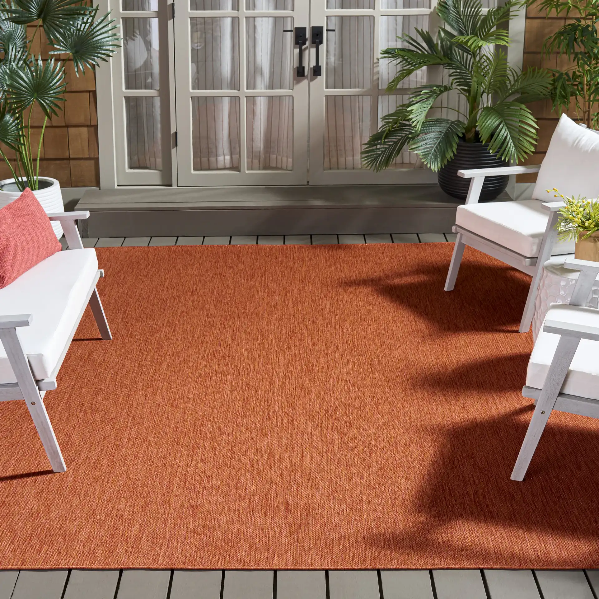 Beach House Textured Solid Outdoor Rug in Orange in a styled room