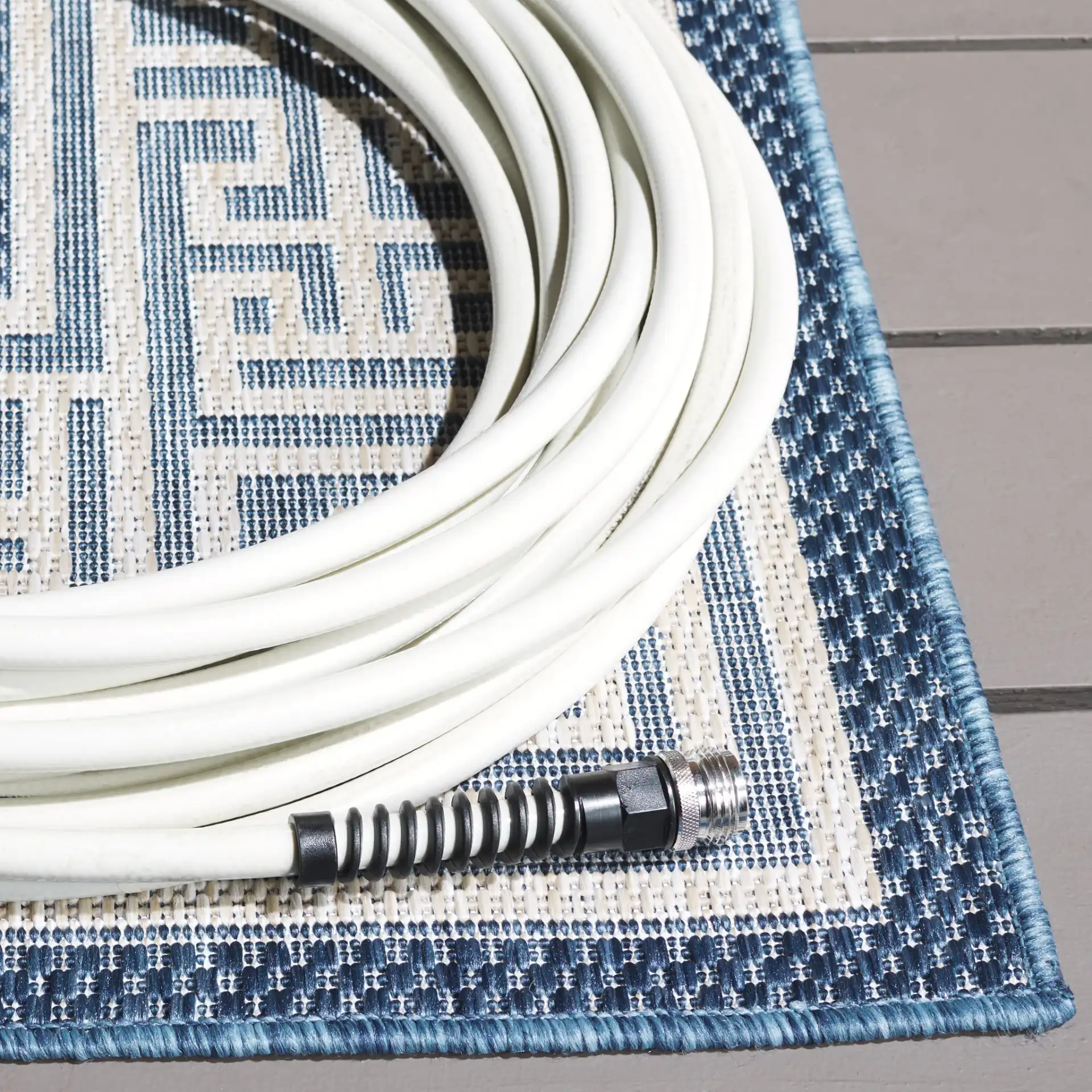 Beach House Greek Key Border Outdoor Rug in Blue / Ivory in a styled room