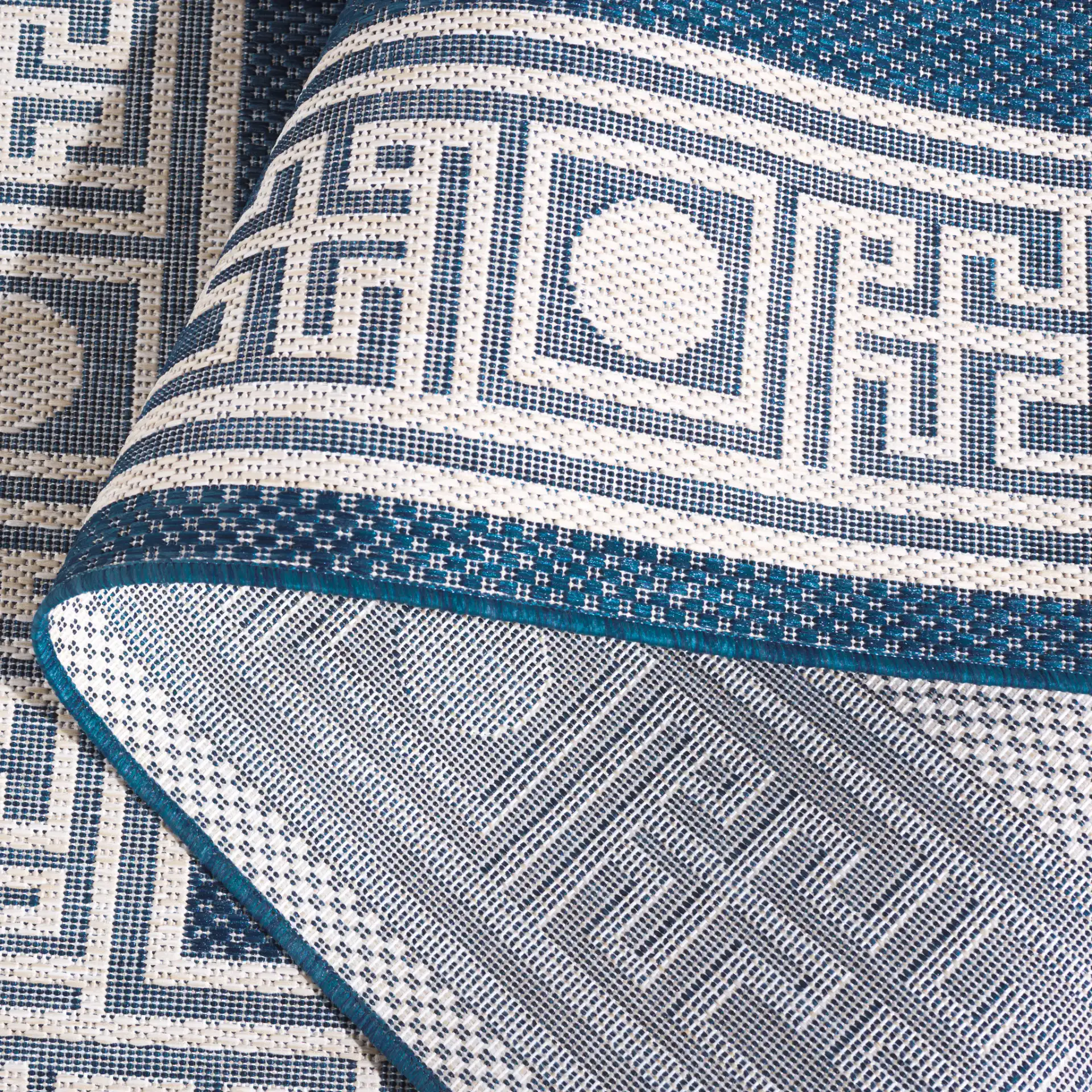 Beach House Greek Key Border Outdoor Rug in Blue / Ivory in a styled room