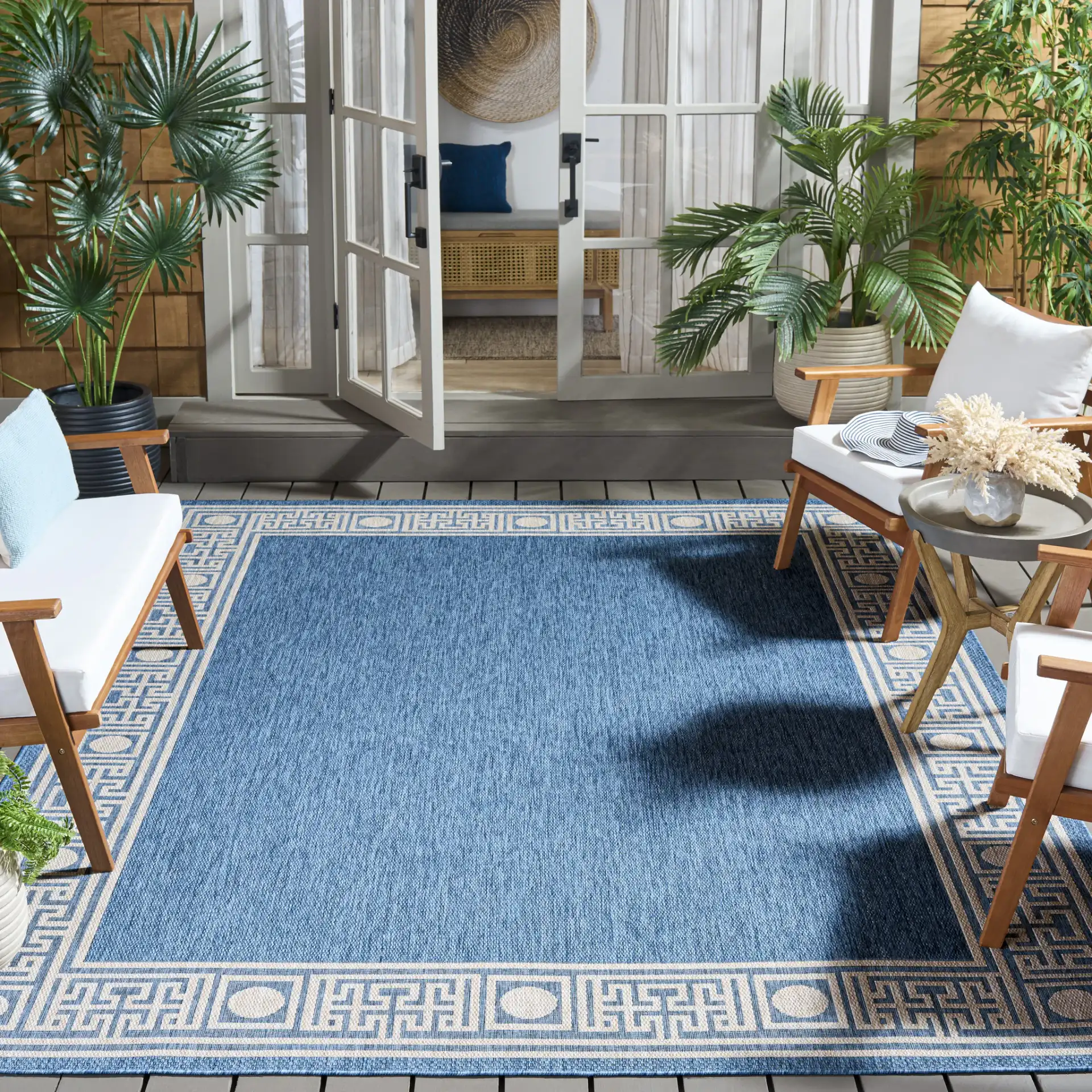 Beach House Greek Key Border Outdoor Rug in Blue / Ivory in a styled room
