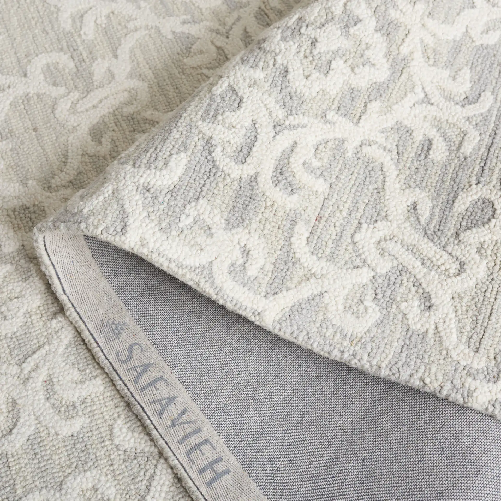 Blossom Scrollwork Hand-Tufted Wool Rug in Gray / Ivory in a styled room