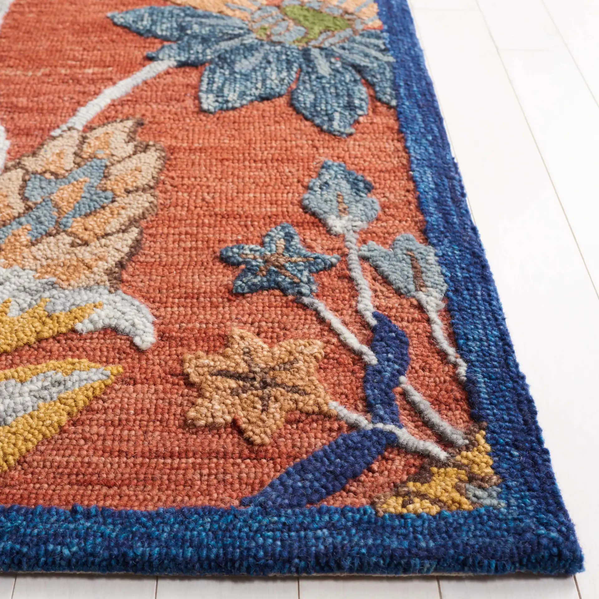 Blossom Botanical Bordered Wool Rug in Orange / Blue in a styled room