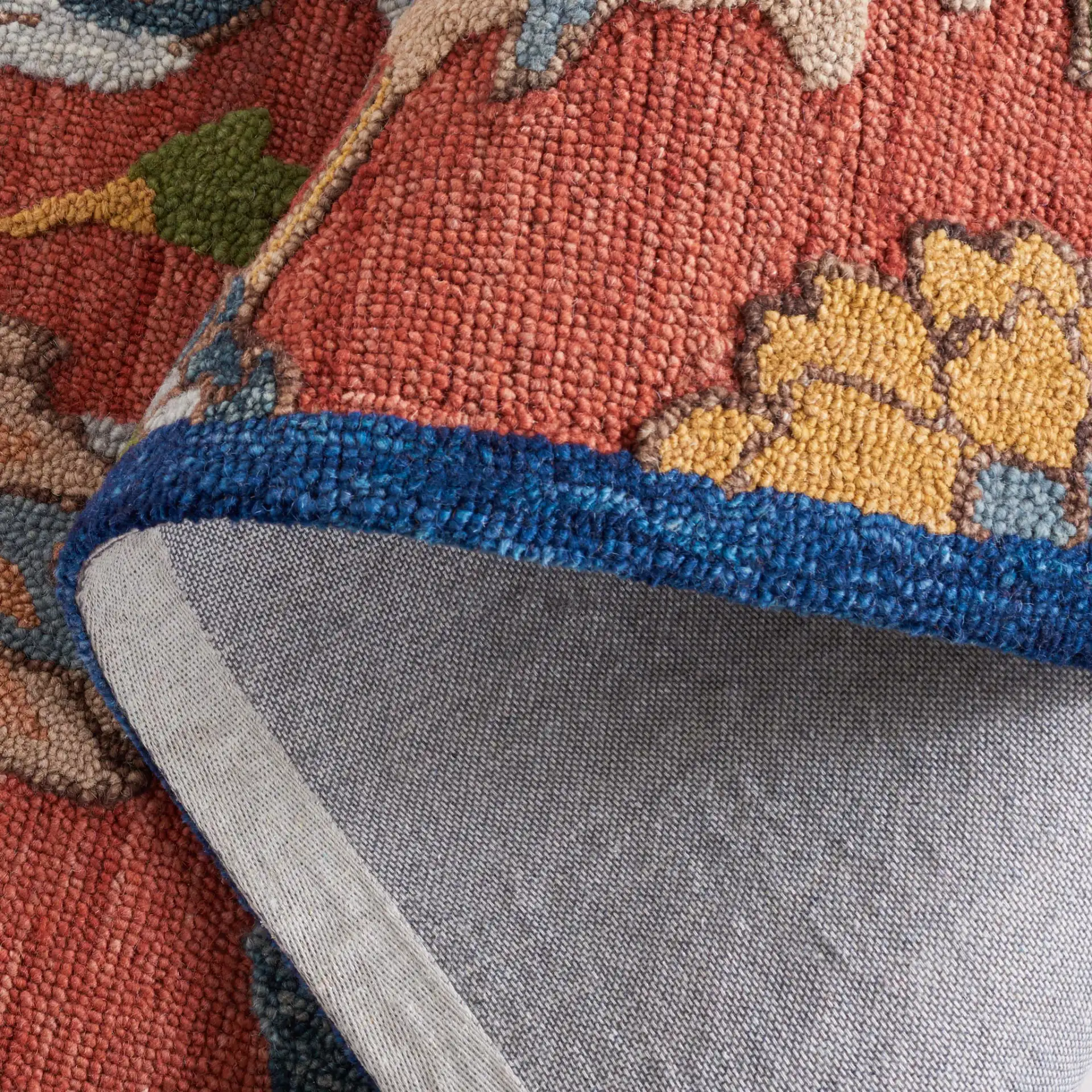 Blossom Botanical Bordered Wool Rug in Orange / Blue in a styled room