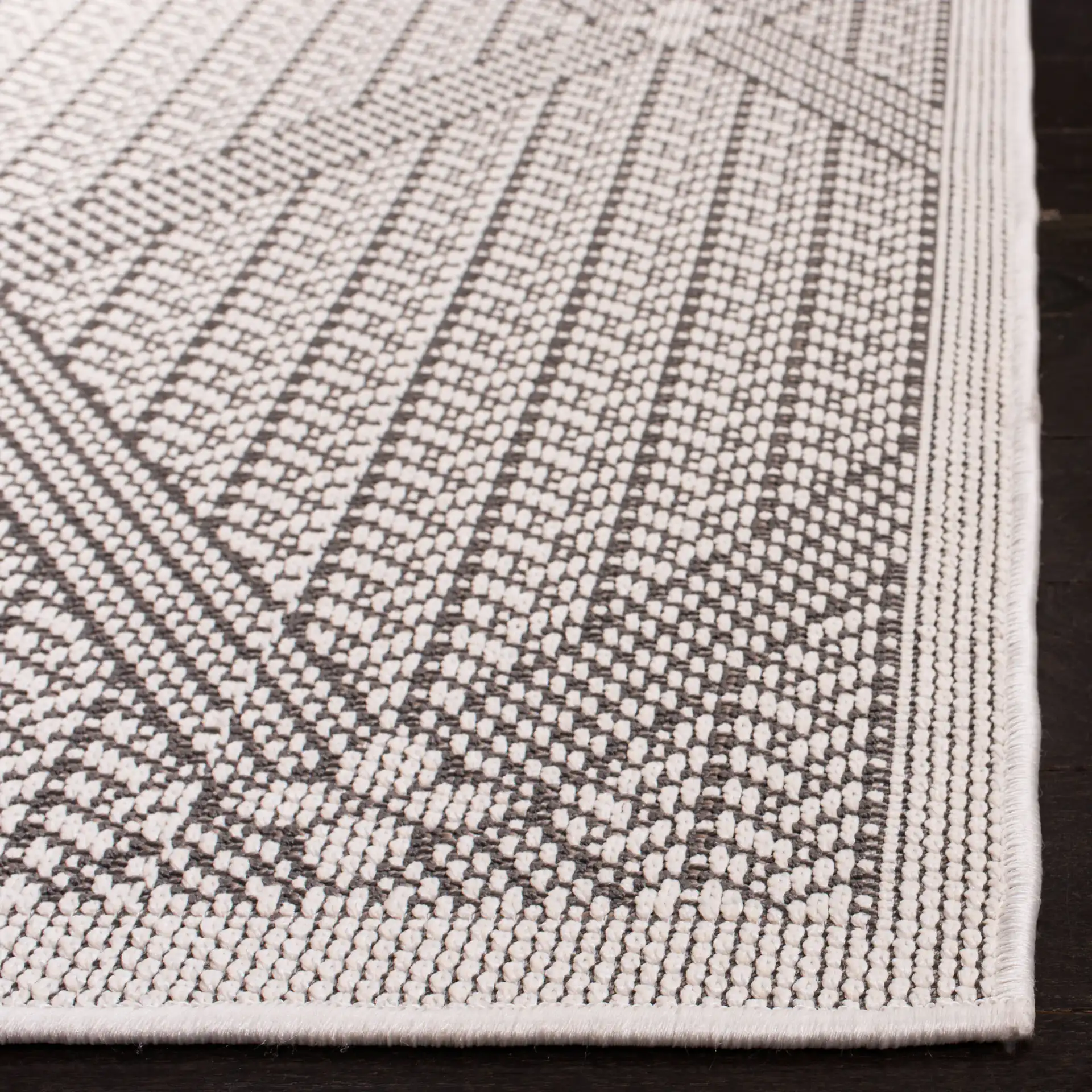 Bermuda Diamond Lattice Washable Outdoor Rug in Cream / Gray in a styled room