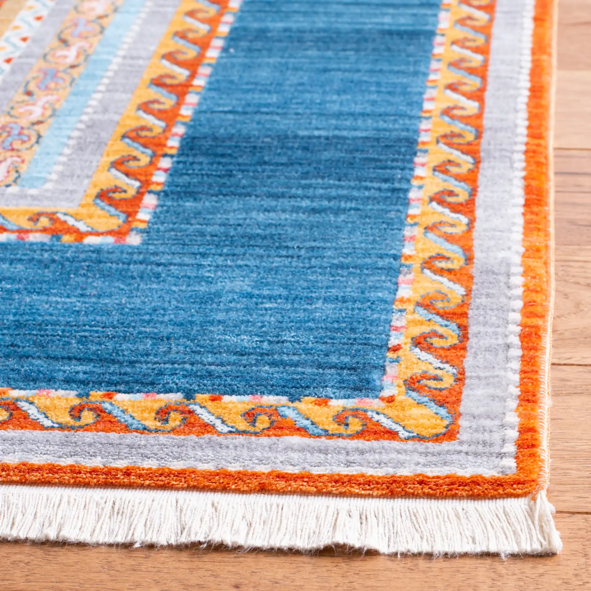 Bokhara Striped Border Rug in Blue / Orange in a styled room