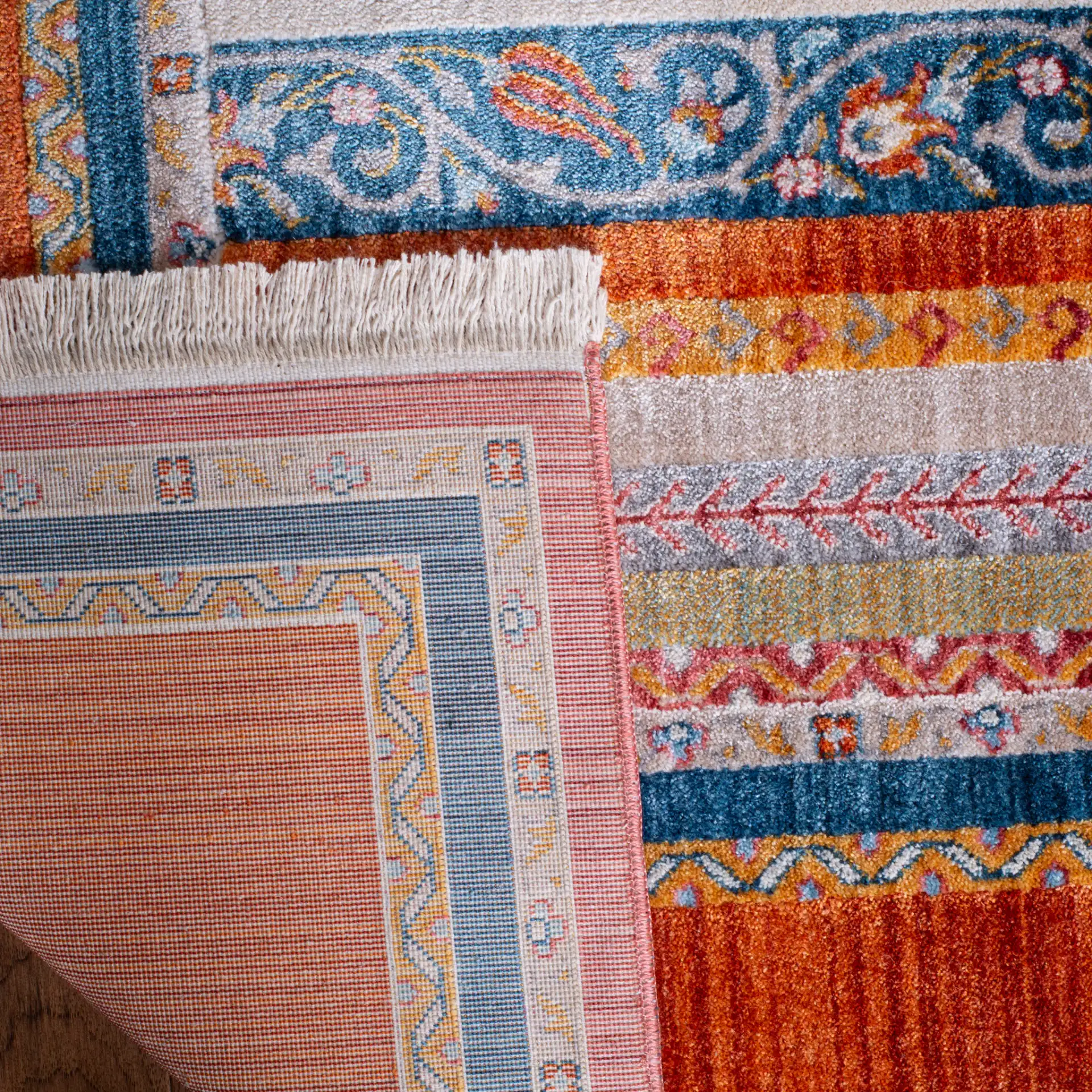 Bokhara Floral Stripe Bordered Rug in Orange / Blue in a styled room