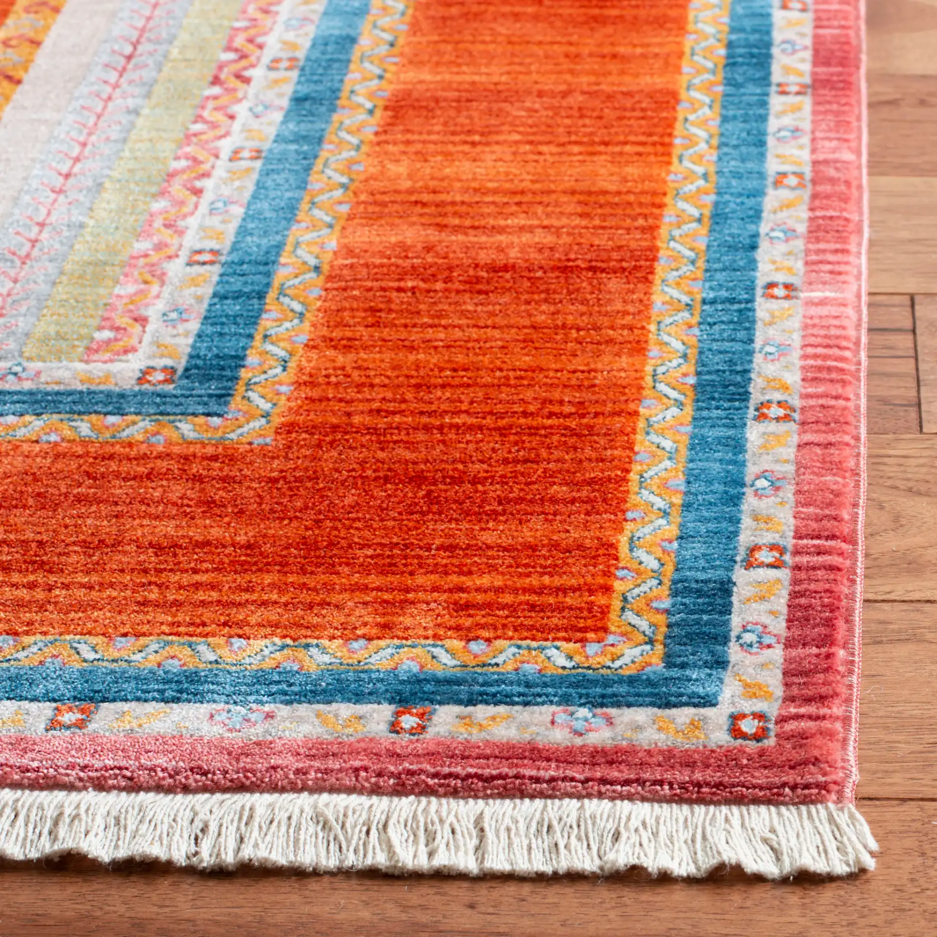 Bokhara Floral Stripe Bordered Rug in Orange / Blue in a styled room