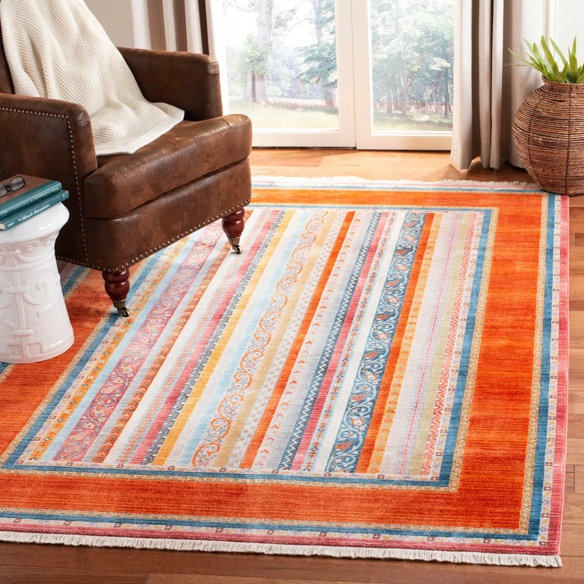 Bokhara Floral Stripe Bordered Rug in Orange / Blue in a styled room