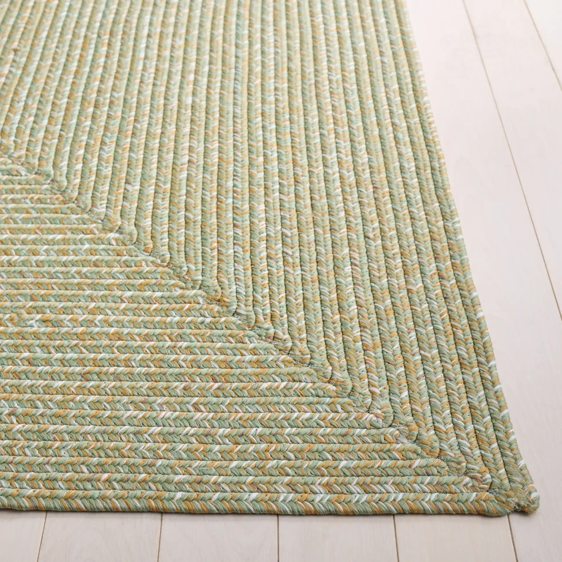 Braided Coastal Heathered Washable Outdoor Rug in Light Green / Sage in a styled room