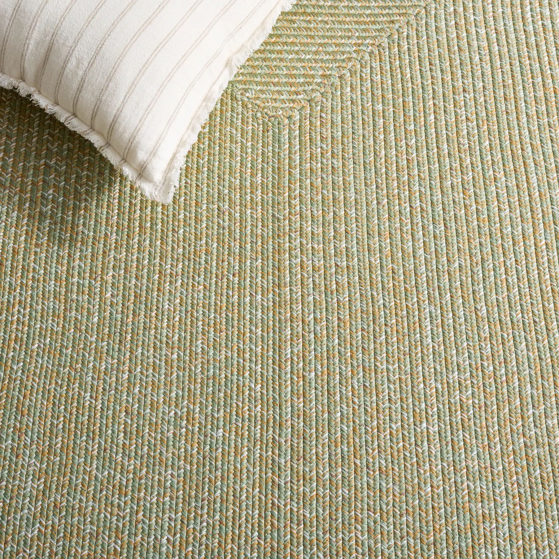 Braided Coastal Heathered Washable Outdoor Rug in Light Green / Sage in a styled room
