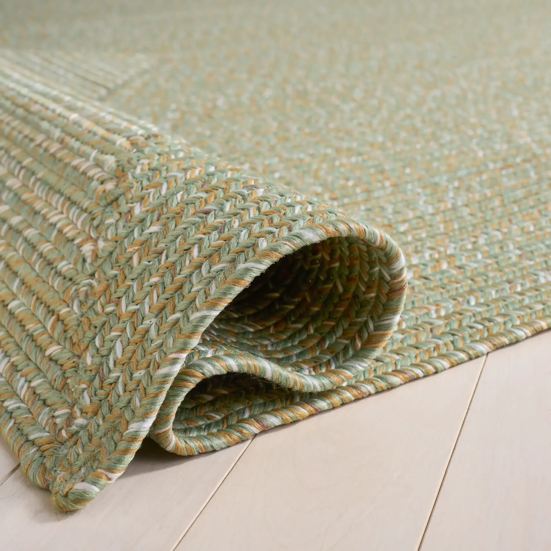 Braided Coastal Heathered Washable Outdoor Rug in Light Green / Sage in a styled room