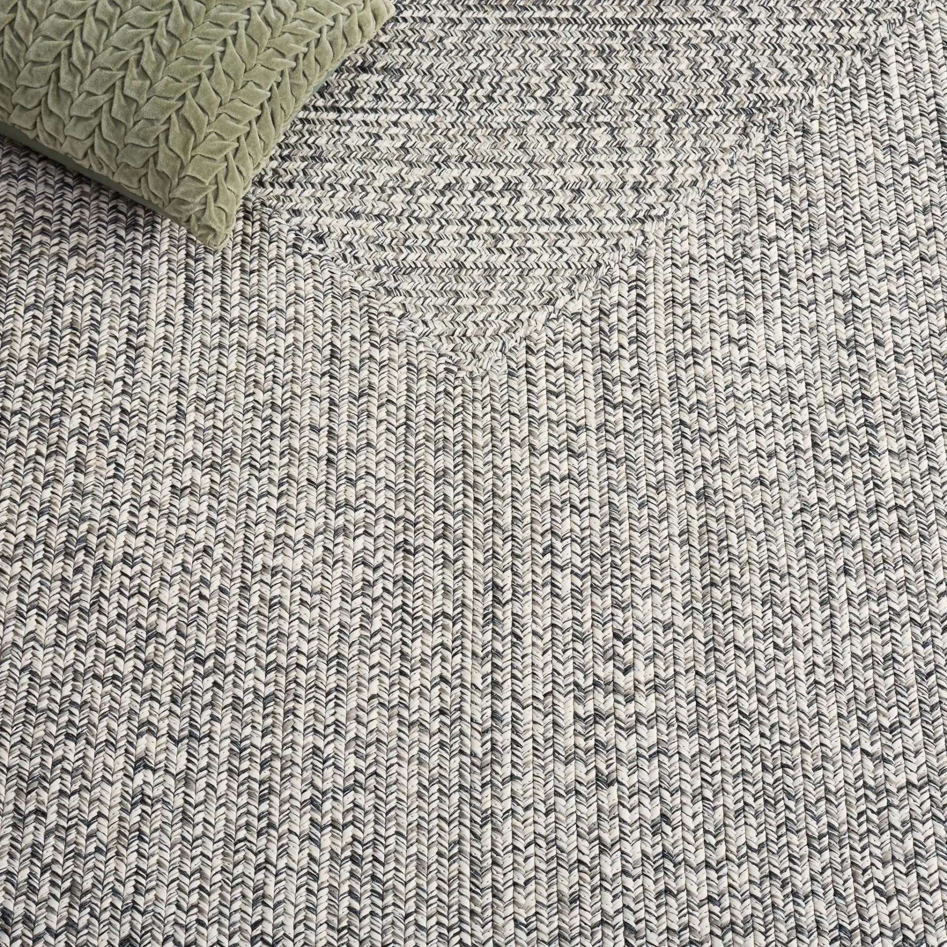 Braided Transitional Border Washable Outdoor Rug in Ivory / Gray Black in a styled room