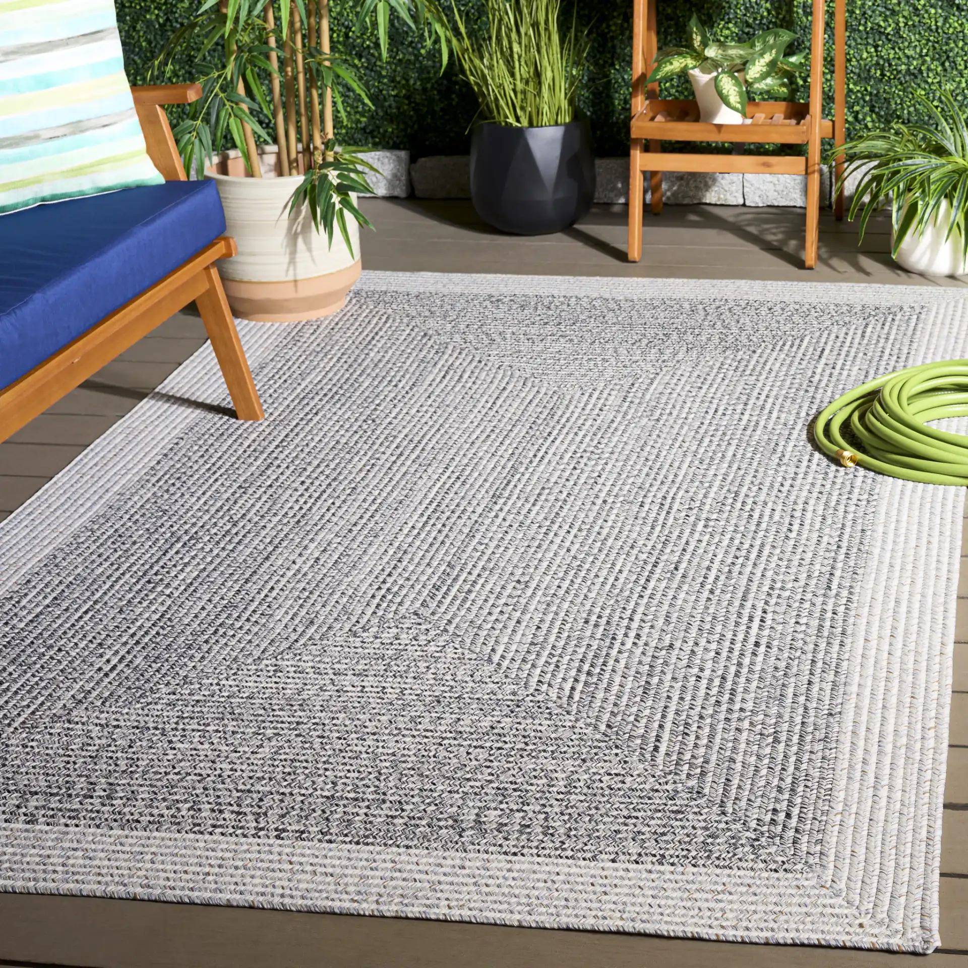 Braided Transitional Border Washable Outdoor Rug in Ivory / Gray Black in a styled room