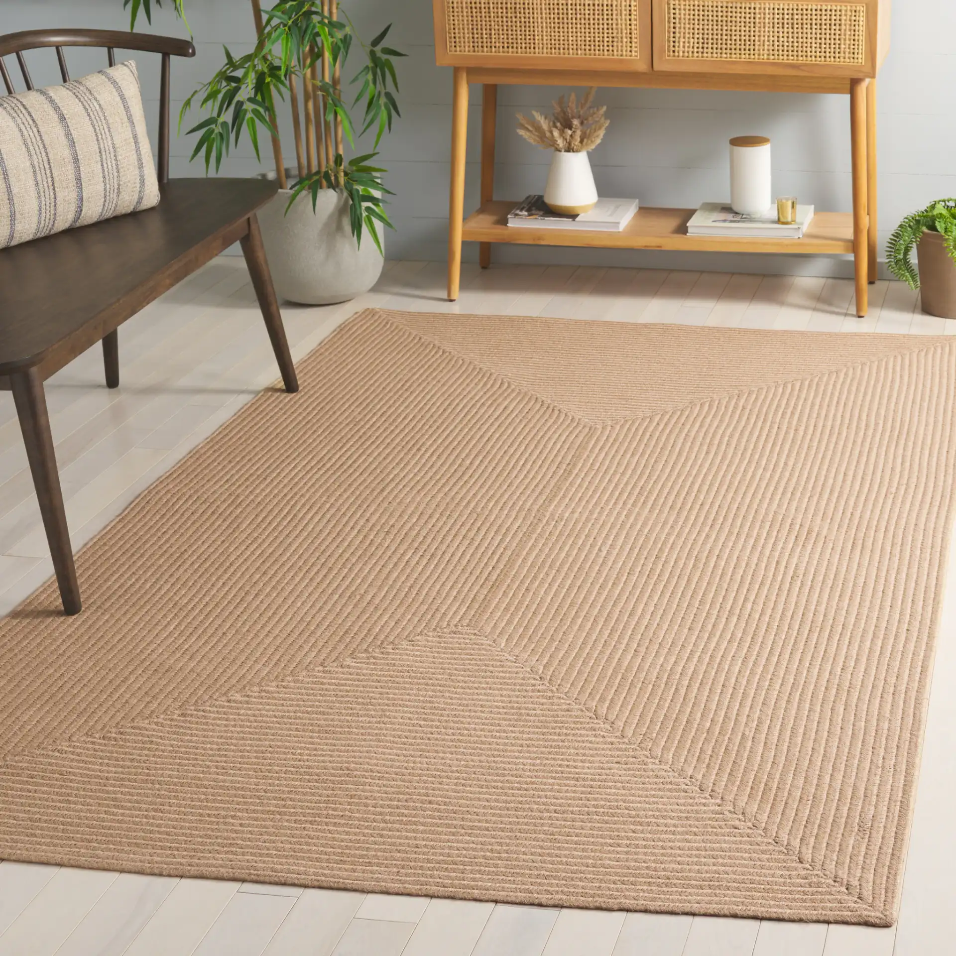 Braided Solid Oval Hand-Woven Rug in Natural in a styled room