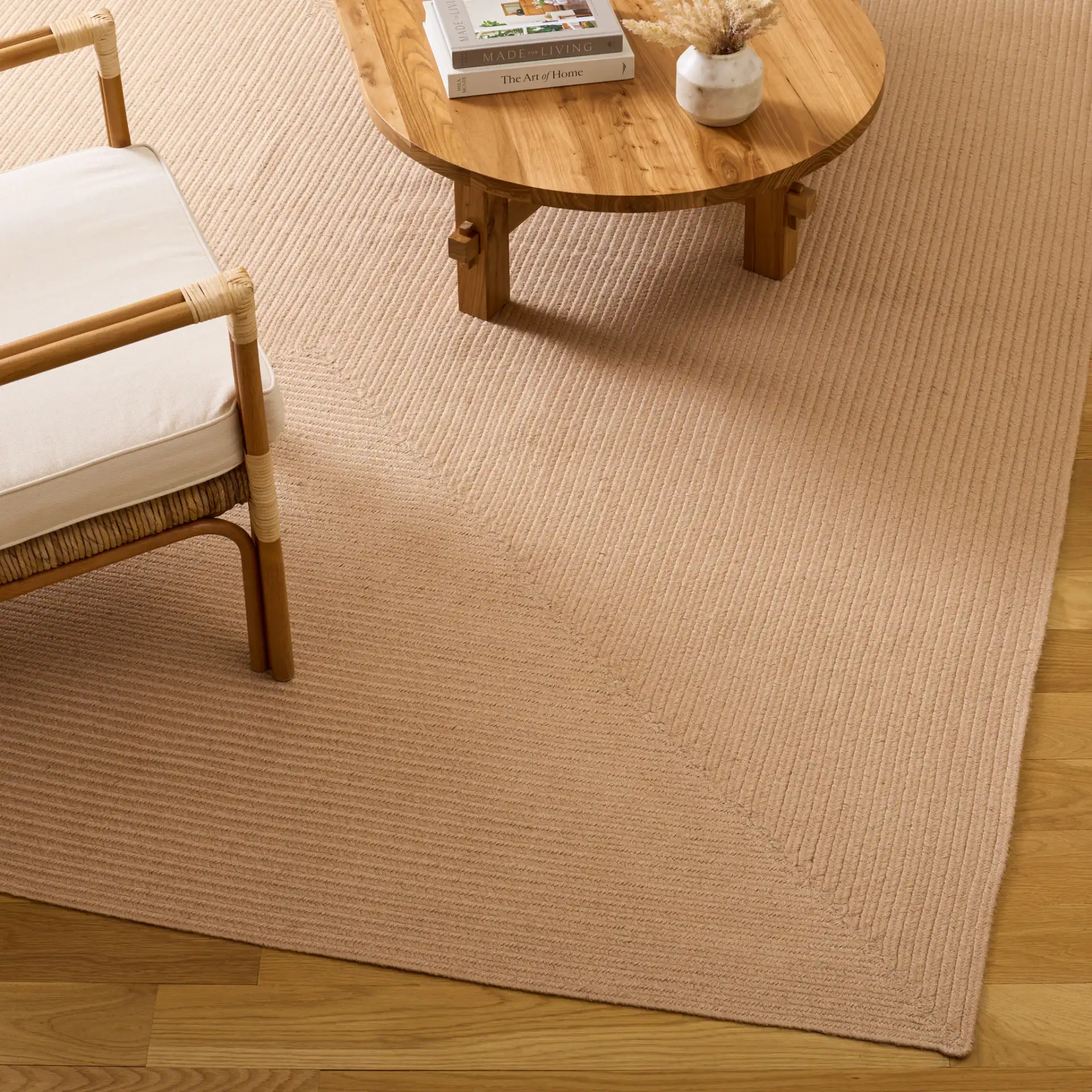 Braided Solid Oval Hand-Woven Rug in Natural in a styled room
