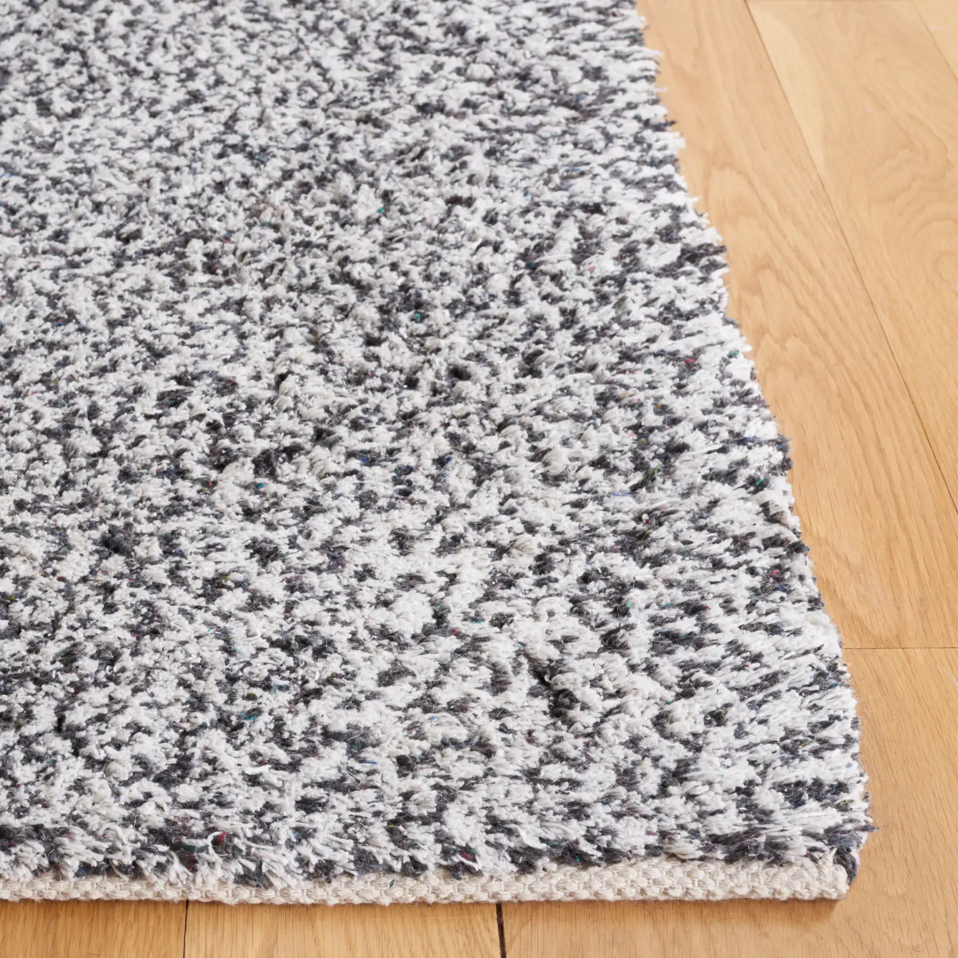 Berber Modern Solid Hand-Woven Wool Blend Rug in Ivory / Black in a styled room