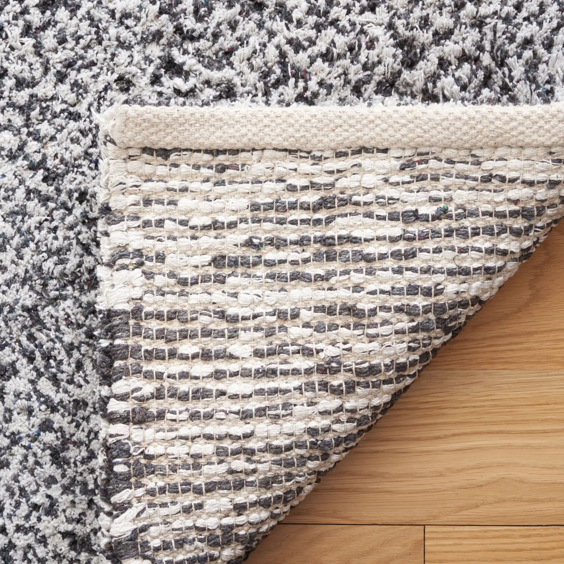 Berber Modern Solid Hand-Woven Wool Blend Rug in Ivory / Black in a styled room