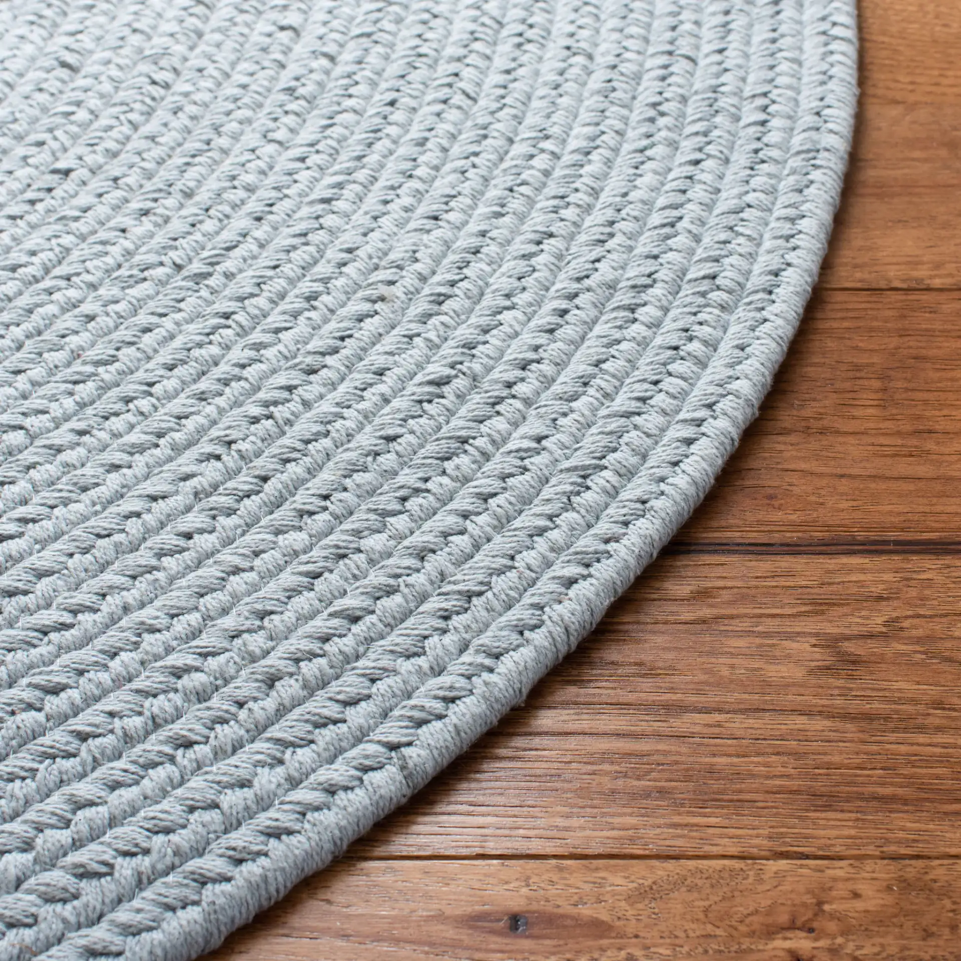 Braided Coastal Oval Hand-Woven Cotton Rug in Light Blue in a styled room