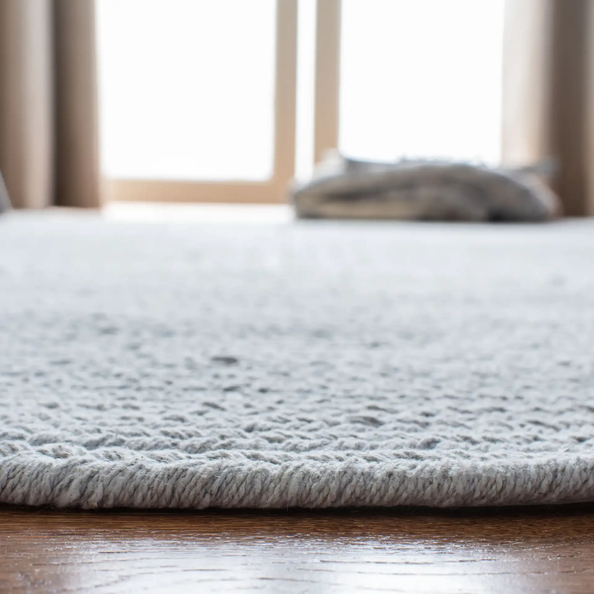 Braided Coastal Oval Hand-Woven Cotton Rug in Light Blue in a styled room