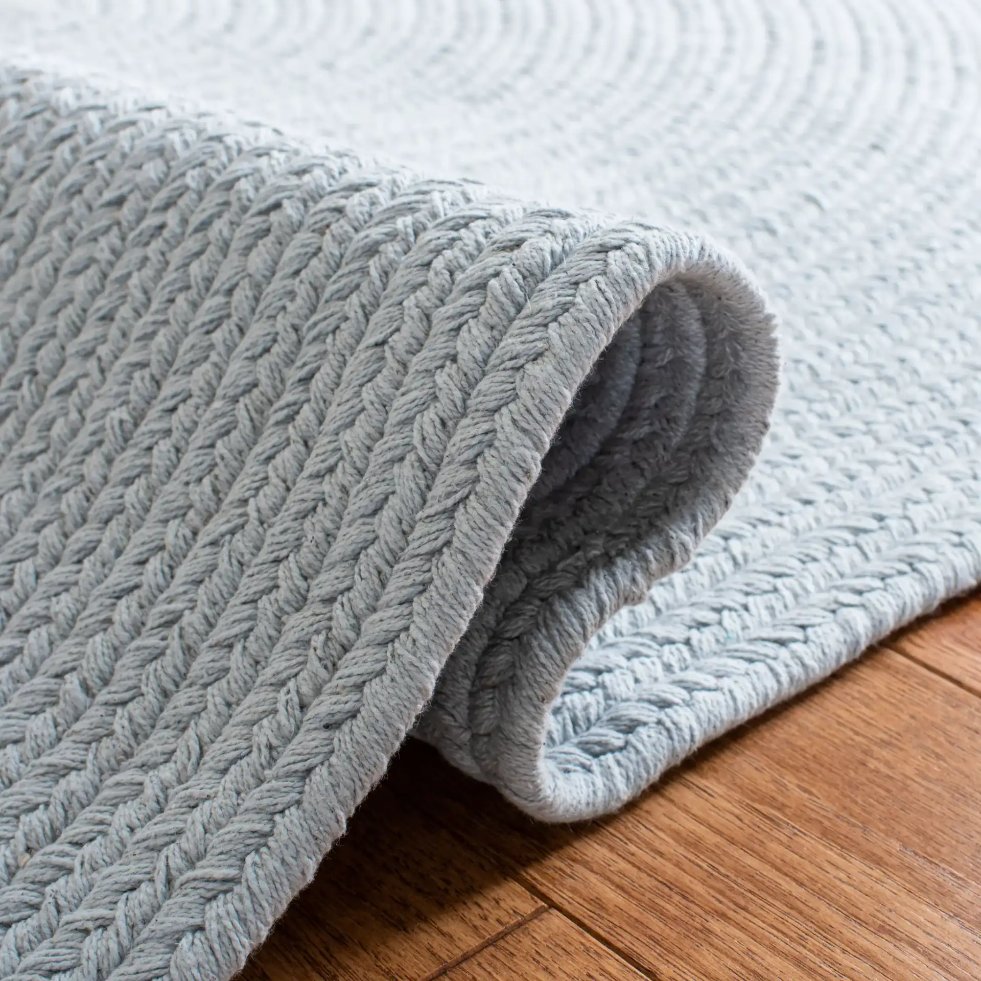 Braided Coastal Oval Hand-Woven Cotton Rug in Light Blue in a styled room