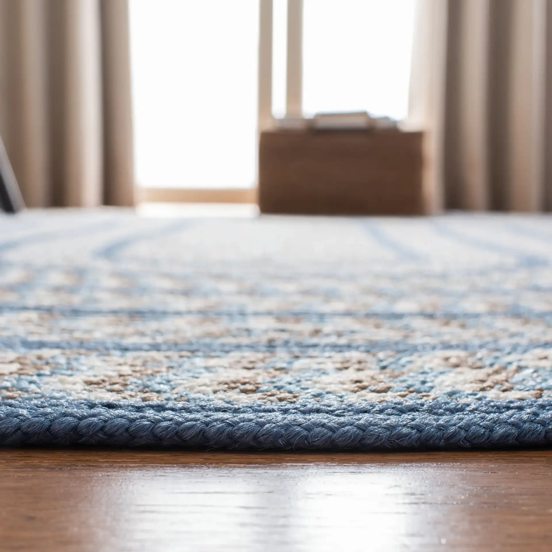 Braided Concentric Oval Hand-Woven Rug in Ivory / Blue in a styled room