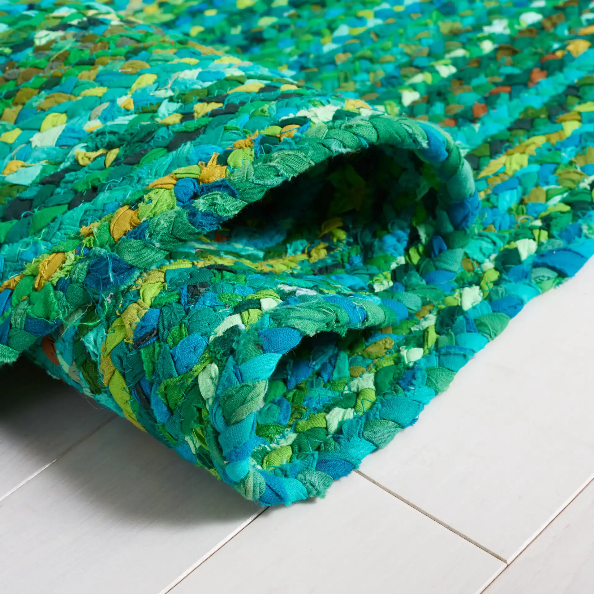 Braided Coastal Spiral Hand-Woven Cotton Rug in Green in a styled room