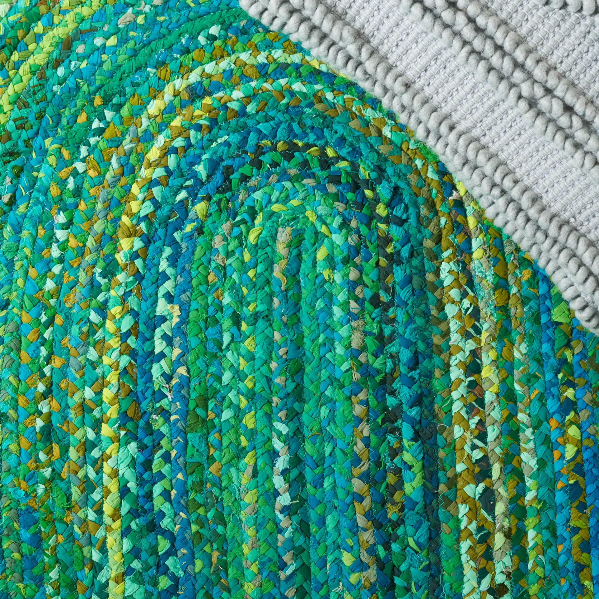 Braided Coastal Spiral Hand-Woven Cotton Rug in Green in a styled room