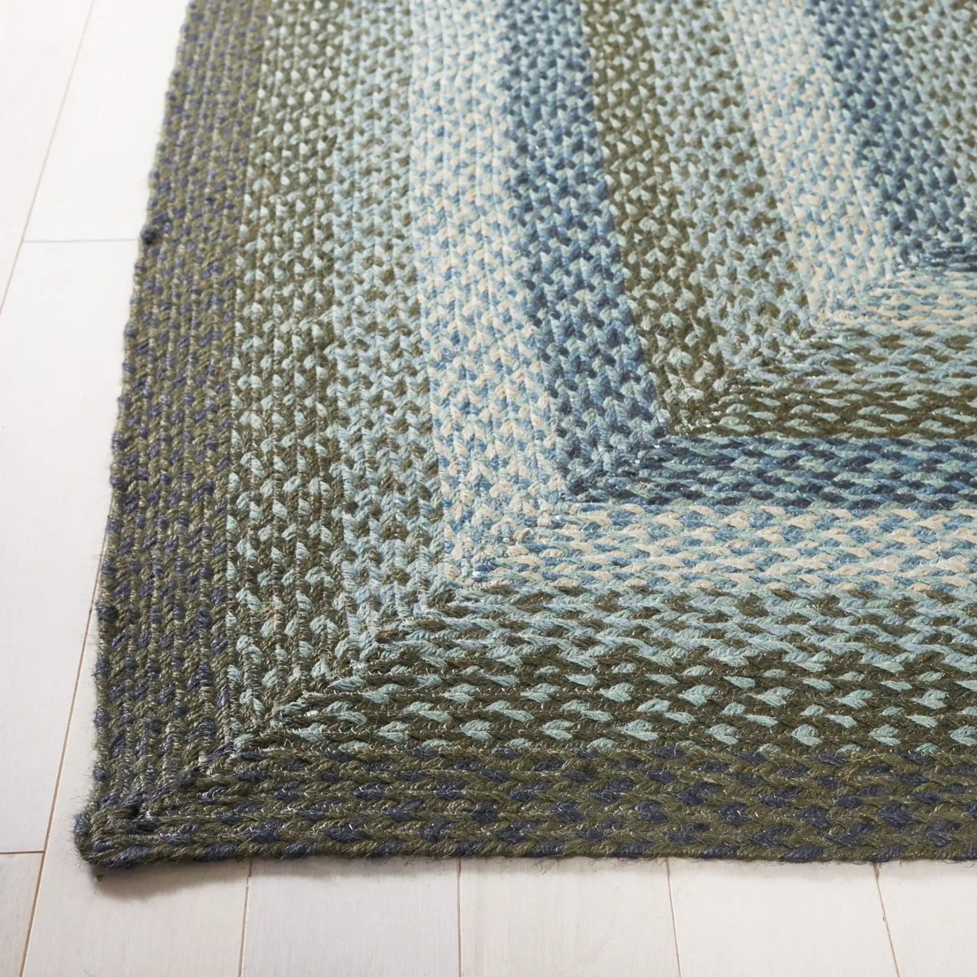 Braided Coastal Geometric Jute Rug in Light Blue / Green in a styled room